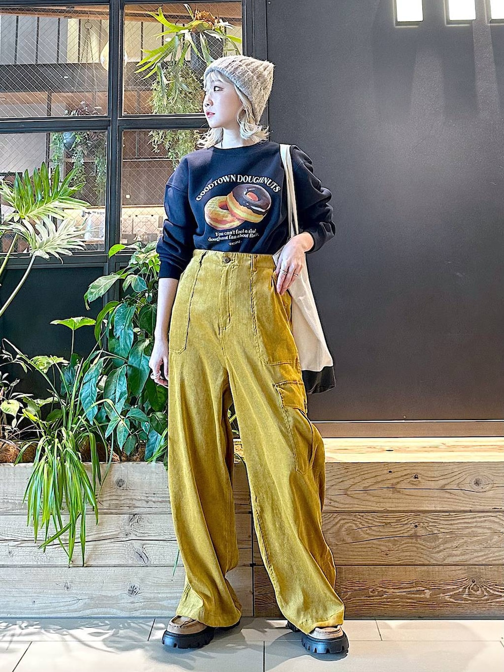 ブラック系のトートバッグ、イエロー系のモカシン/デッキシューズ、イエロー系のカーゴパンツを着用したレディースの秋コーディネートの1枚目の写真