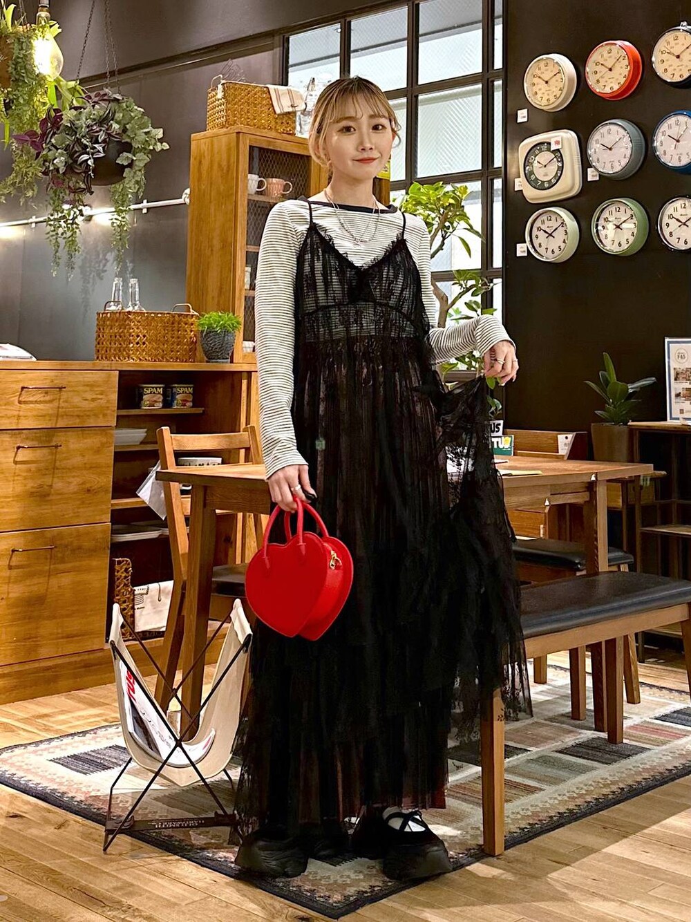 ブラック系のスニーカー、グレー系のワンピース、レッド系のショルダーバッグを着用したレディースの春コーディネートの1枚目の写真