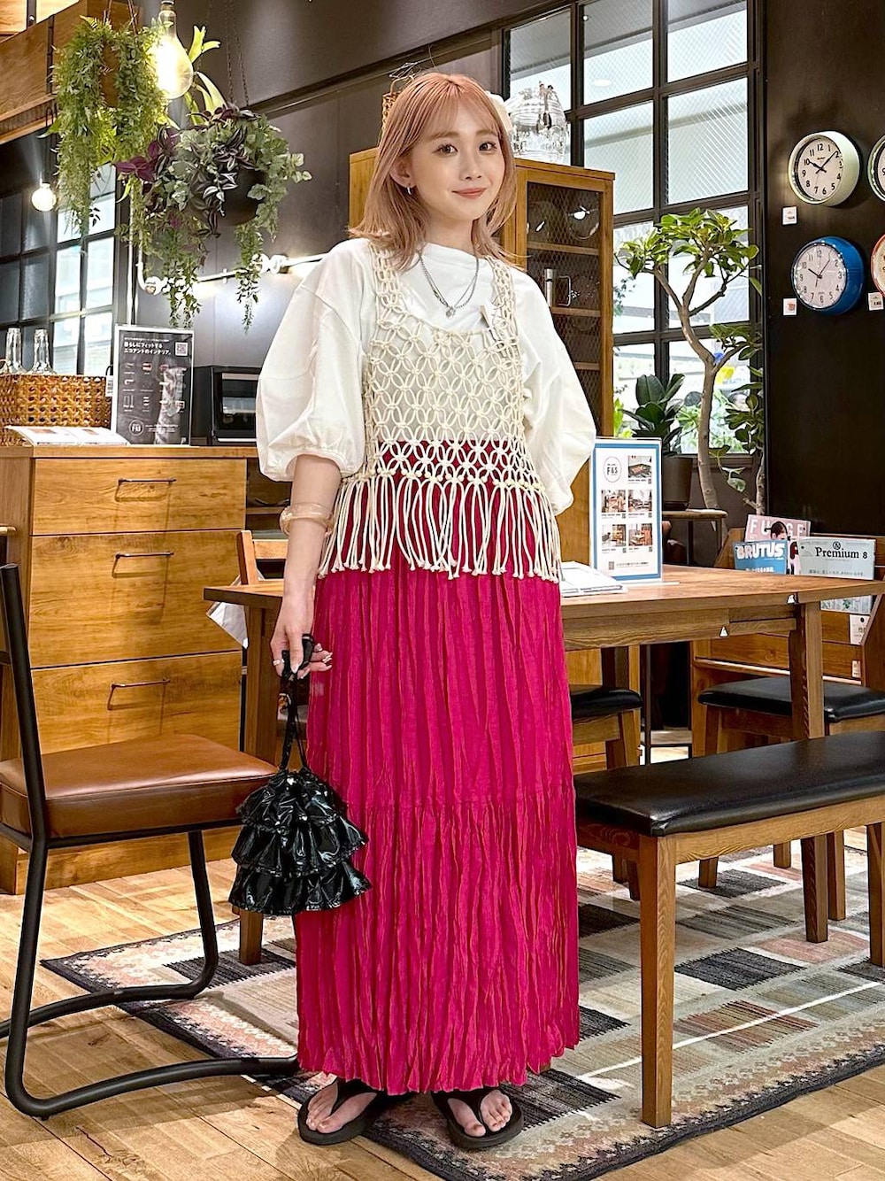 ブラック系のショルダーバッグ、ピンク系のスカート、ホワイト系のTシャツ/カットソーを着用したレディースの春コーディネートの1枚目の写真