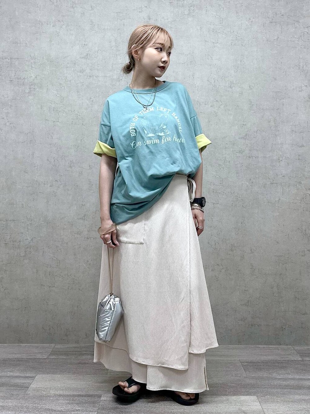 シルバー系のショルダーバッグ、グリーン系のTシャツ/カットソー、ブラック系のサンダルを着用したレディースの春コーディネートの1枚目の写真