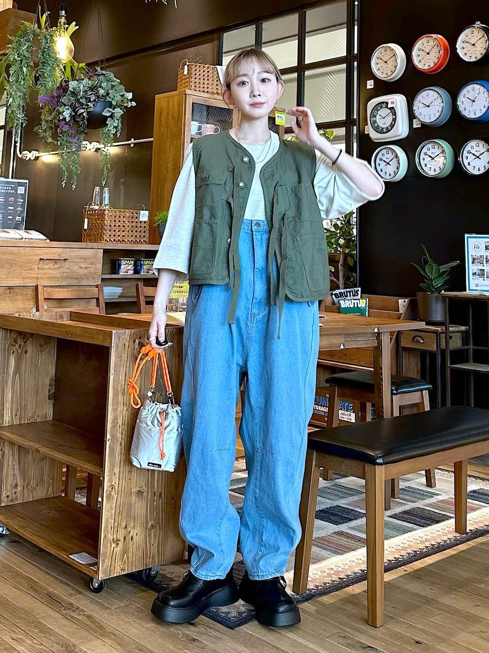 ブルー系のその他パンツ、グリーン系のベスト、グレー系のショルダーバッグを着用したレディースの冬コーディネートの1枚目の写真