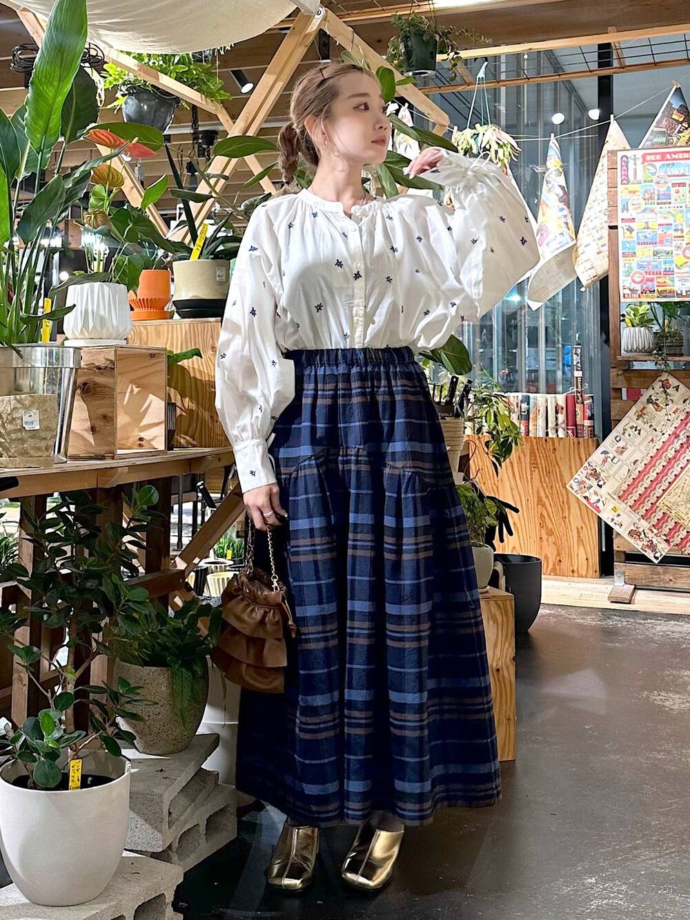 ブルー系のその他パンツ、ゴールド系のブーツ、ブラウン系のショルダーバッグを着用したレディースの夏コーディネートの1枚目の写真