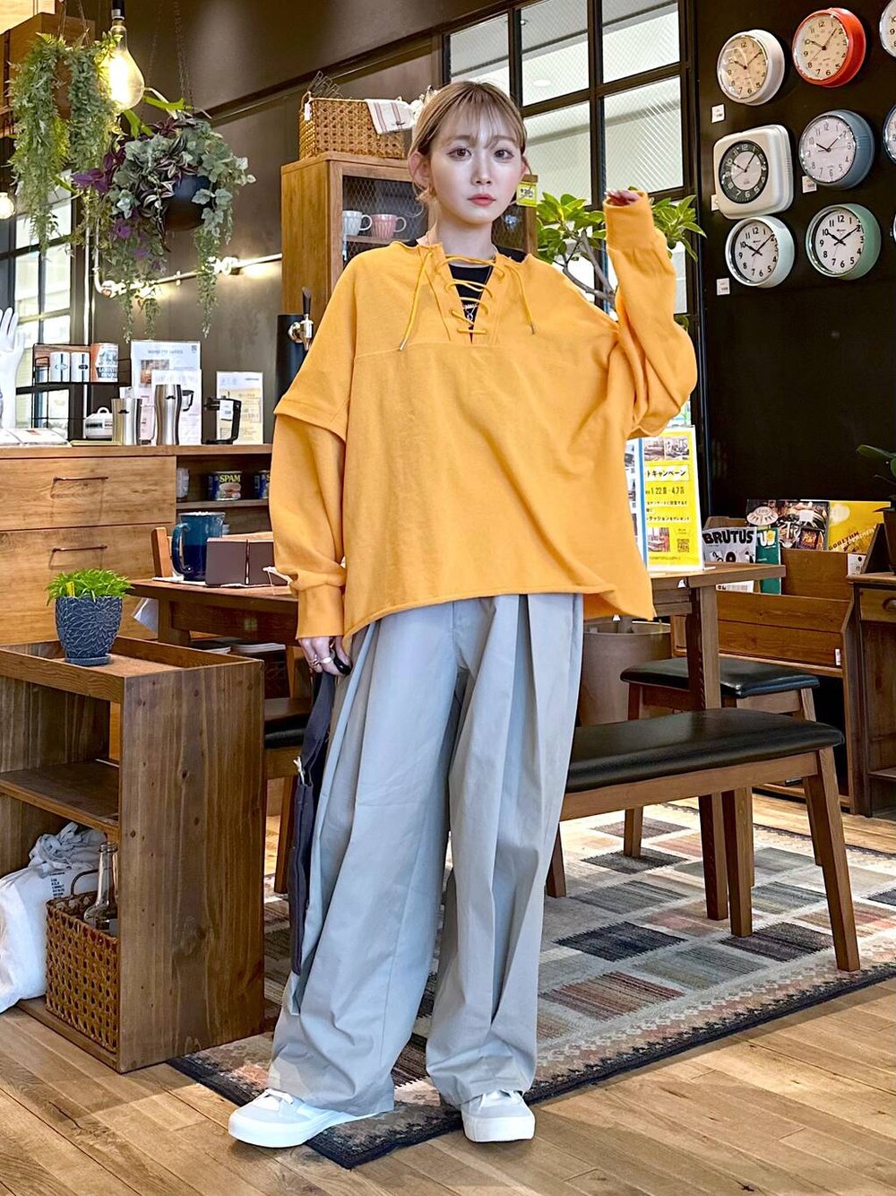 ホワイト系のスニーカー、グレー系のチノパンツ、グレー系のトートバッグを着用したレディースの冬コーディネートの1枚目の写真