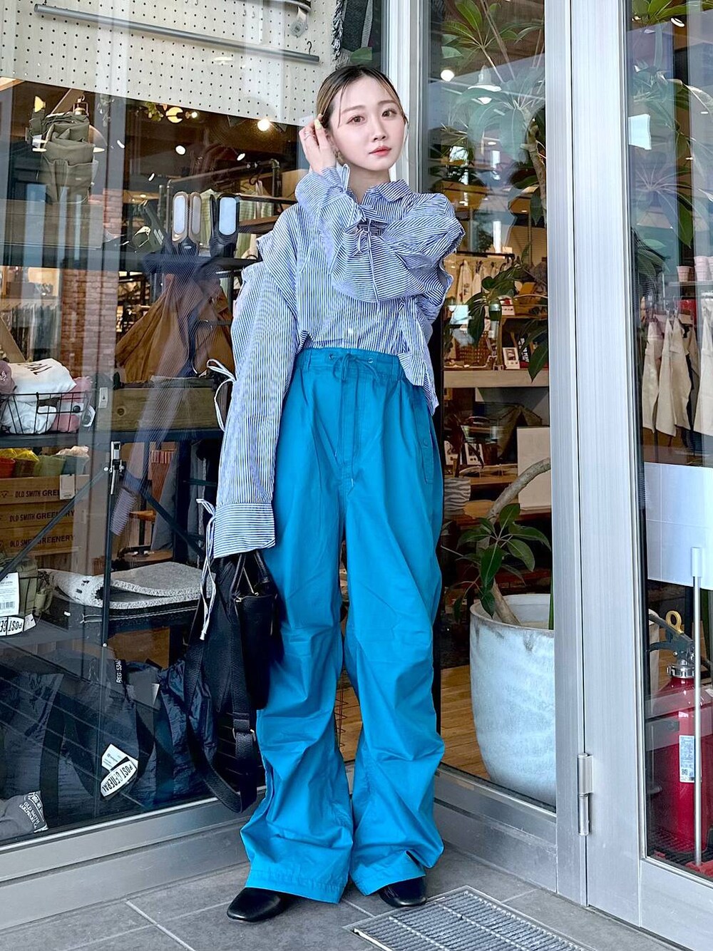 ブラック系のトートバッグ、その他のパンプス、ブルー系のシャツ/ブラウスを着用したレディースの春コーディネートの1枚目の写真
