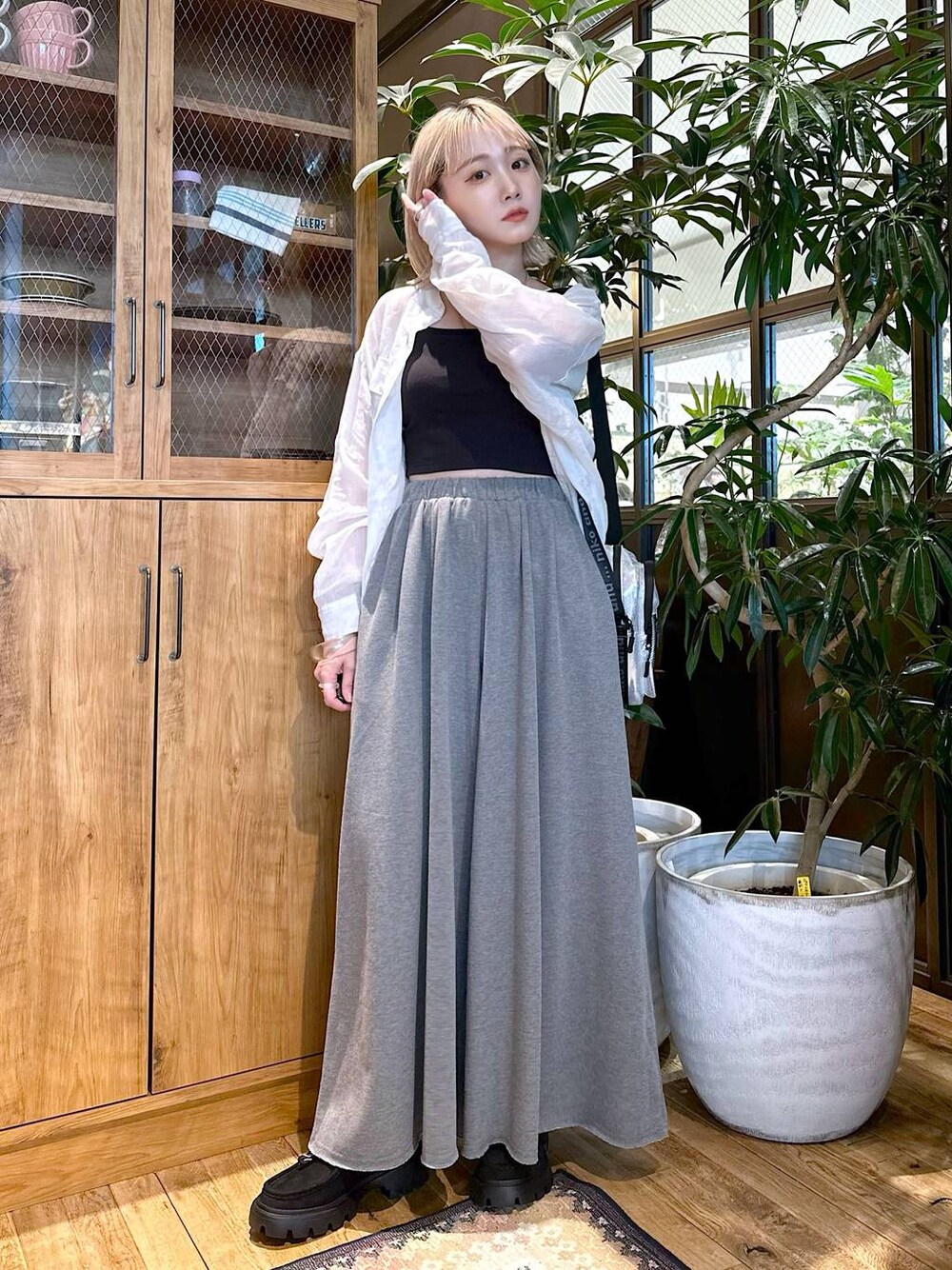 ホワイト系のシャツ/ブラウス、グレー系のショルダーバッグ、ブラック系のモカシン/デッキシューズを着用したレディースの夏コーディネートの1枚目の写真