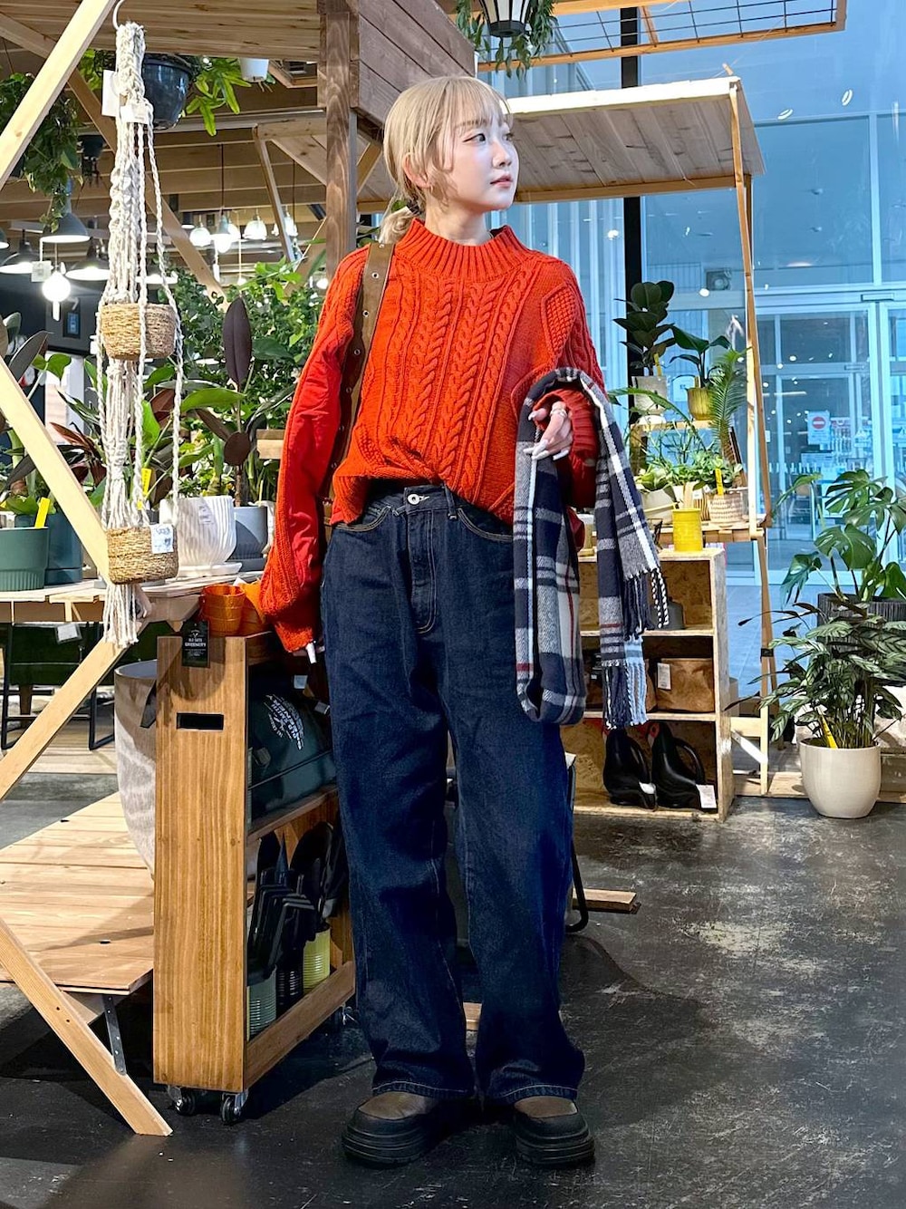 ブルー系のデニムパンツ、ブラウン系のブーツ、ブラウン系のショルダーバッグを着用したレディースの冬コーディネートの1枚目の写真