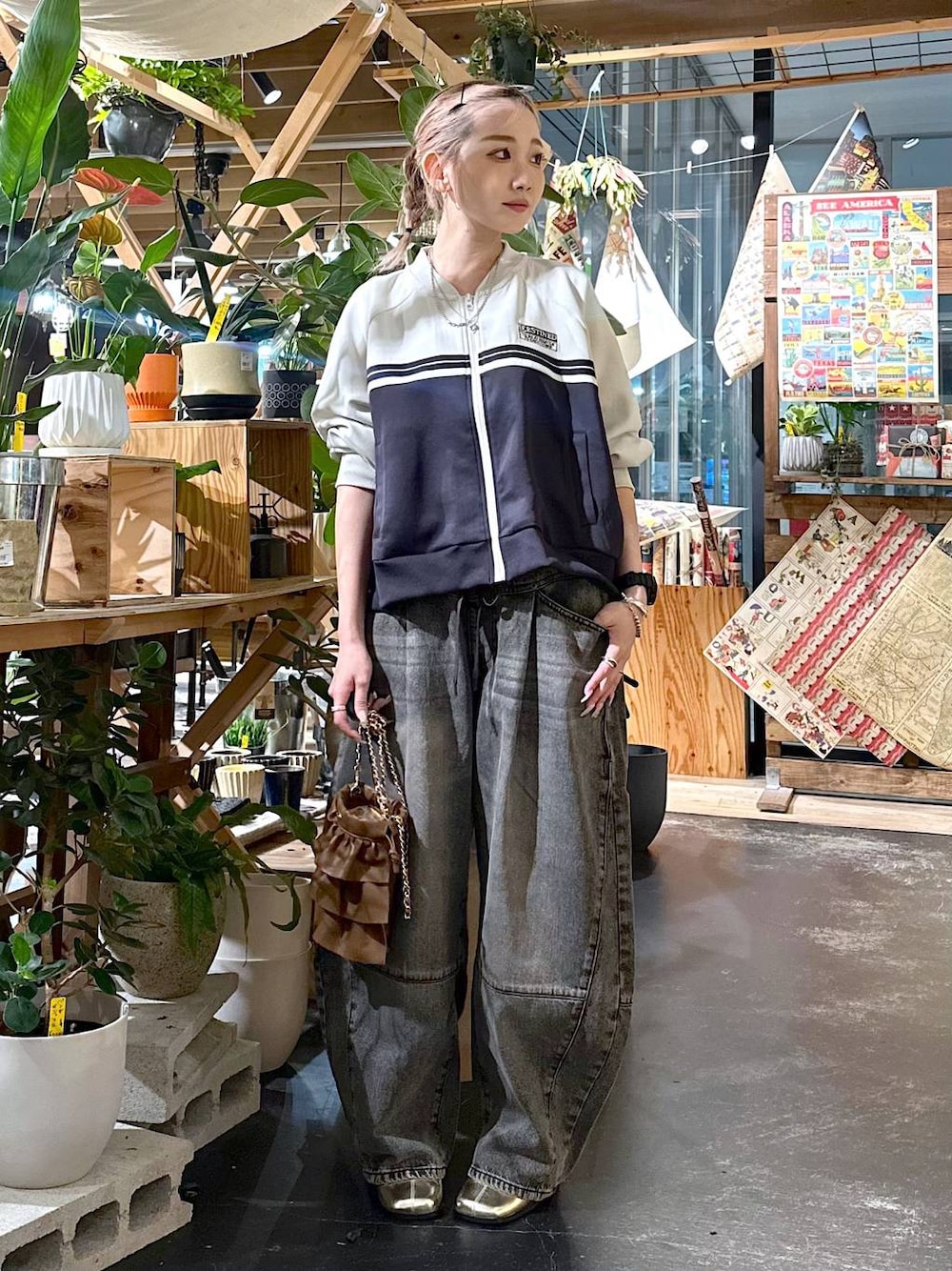 ブラウン系のデニムパンツ、ゴールド系のブーツ、ブラウン系のショルダーバッグを着用したレディースの夏コーディネートの1枚目の写真