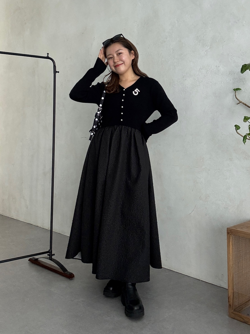 ブラック系のワンピース、ブラック系のブーツを着用したレディースの秋コーディネートの1枚目の写真