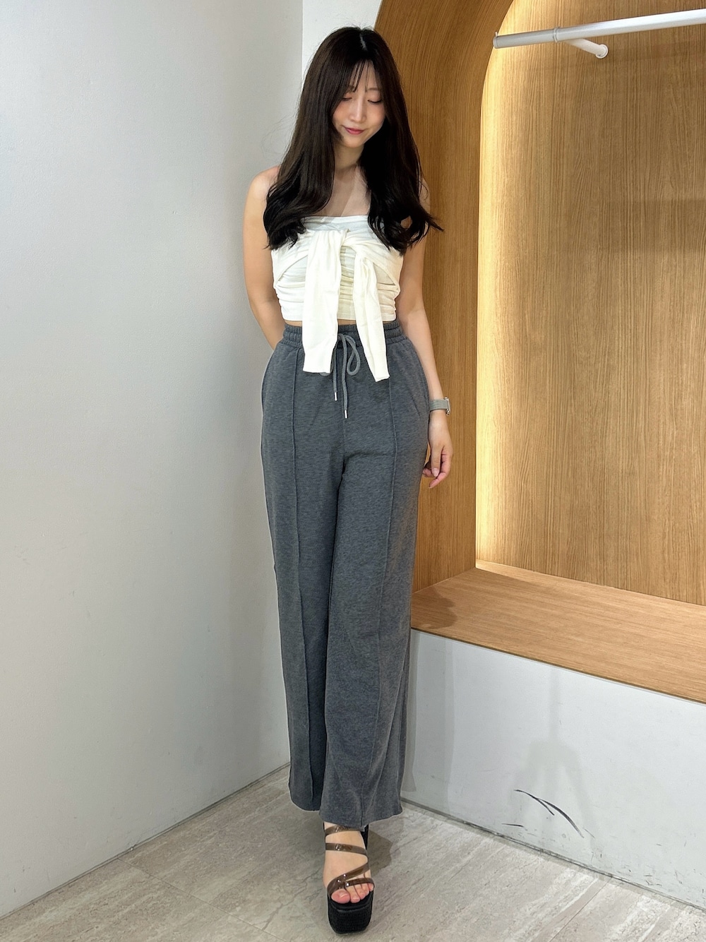 グレー系のスウェットパンツ、ホワイト系のキャミソール、ブラック系のサンダルを着用したレディースの夏コーディネートの1枚目の写真