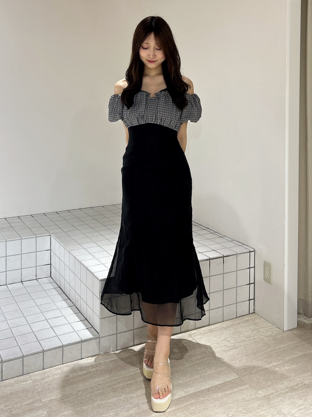 ブラック系のワンピース、ホワイト系のサンダルを着用したレディースの夏コーディネートの1枚目の写真