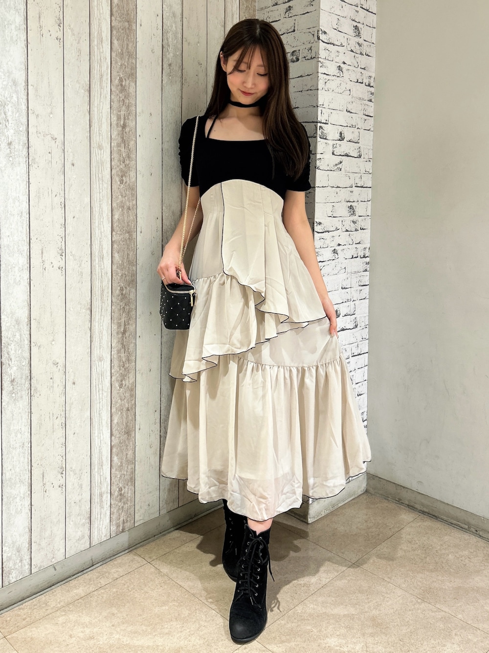 ブラック系のワンピース、ブラック系のショルダーバッグを着用したレディースの春コーディネートの1枚目の写真