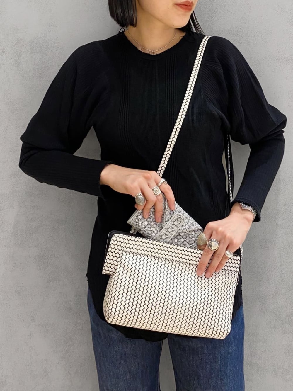 ホワイト系のショルダーバッグ、シルバー系の財布、シルバー系のリングを着用したレディースの冬コーディネートの1枚目の写真