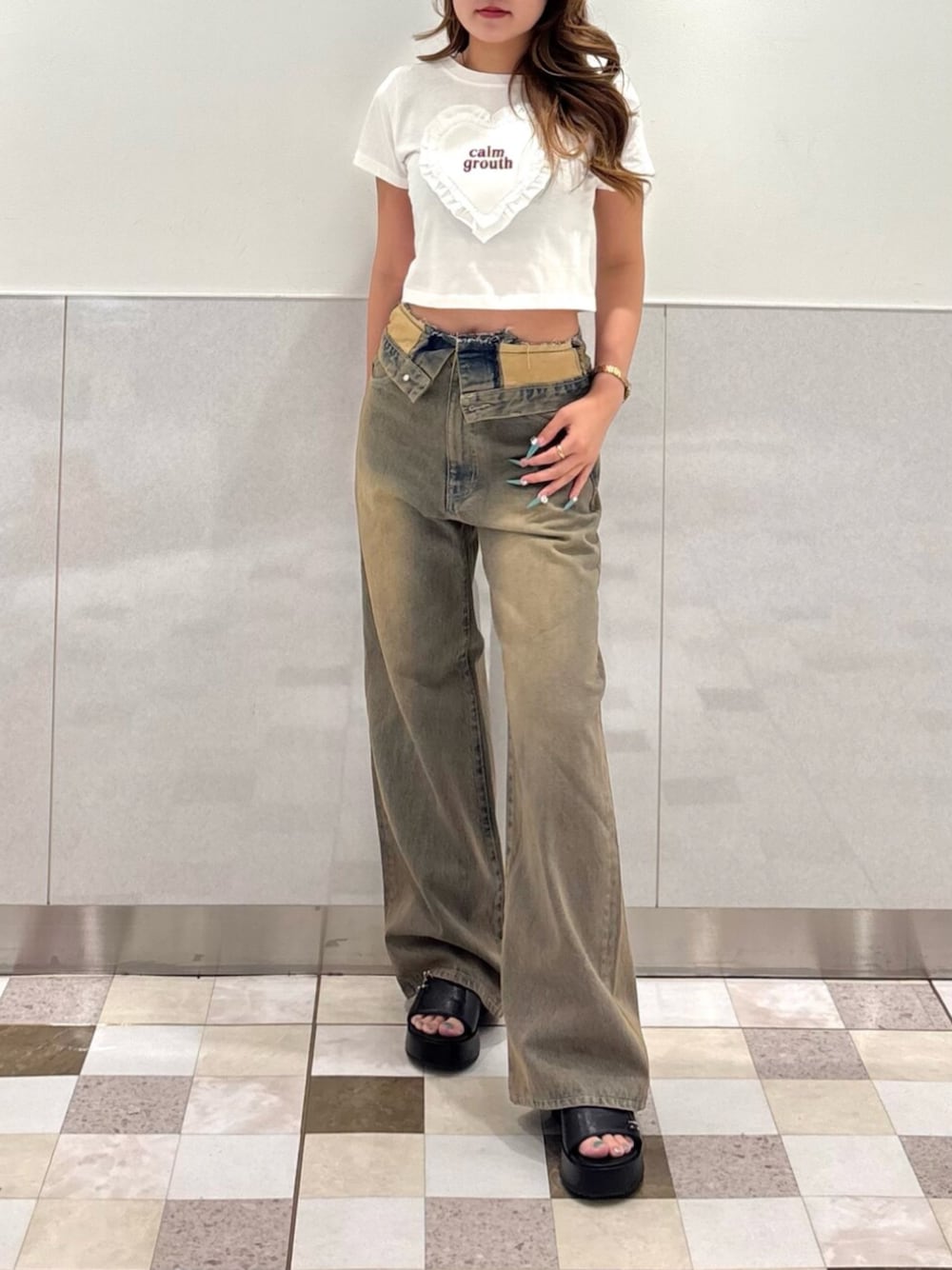 ブラック系のサンダル、ホワイト系のTシャツ/カットソー、ブラウン系のデニムパンツを着用したレディースの夏コーディネートの1枚目の写真