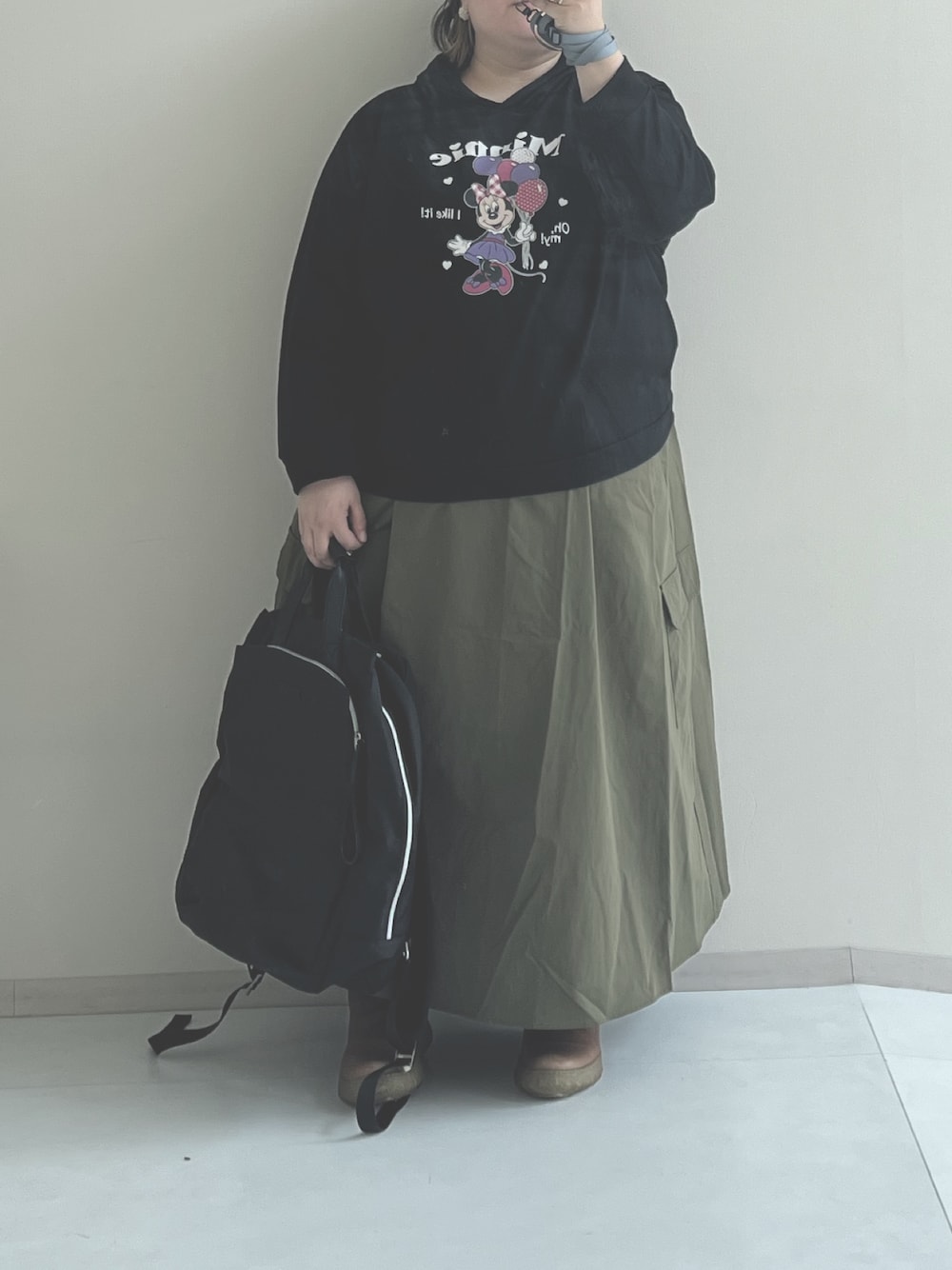 グリーン系のスカート、ブラック系のスウェット、ブラック系のバックパック/リュックを着用したレディースの冬コーディネートの1枚目の写真