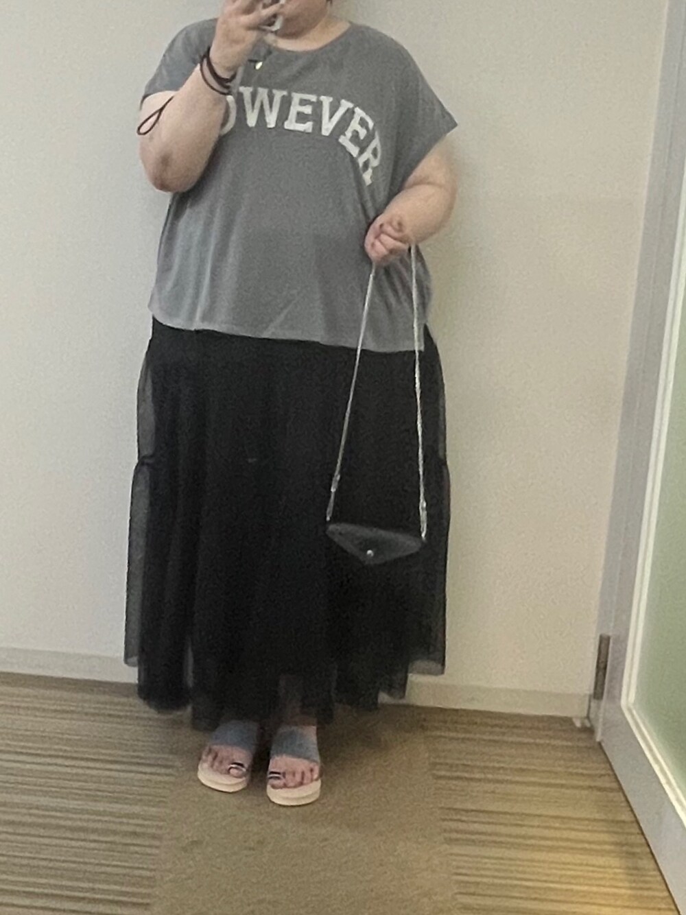 ブラック系のスカート、グレー系のTシャツ/カットソー、ブラック系のショルダーバッグを着用したレディースの夏コーディネートの1枚目の写真