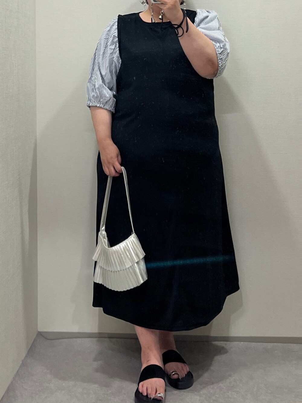 シルバー系のトートバッグ、ブラック系のワンピース、ブラック系のサンダルを着用したレディースの夏コーディネートの1枚目の写真