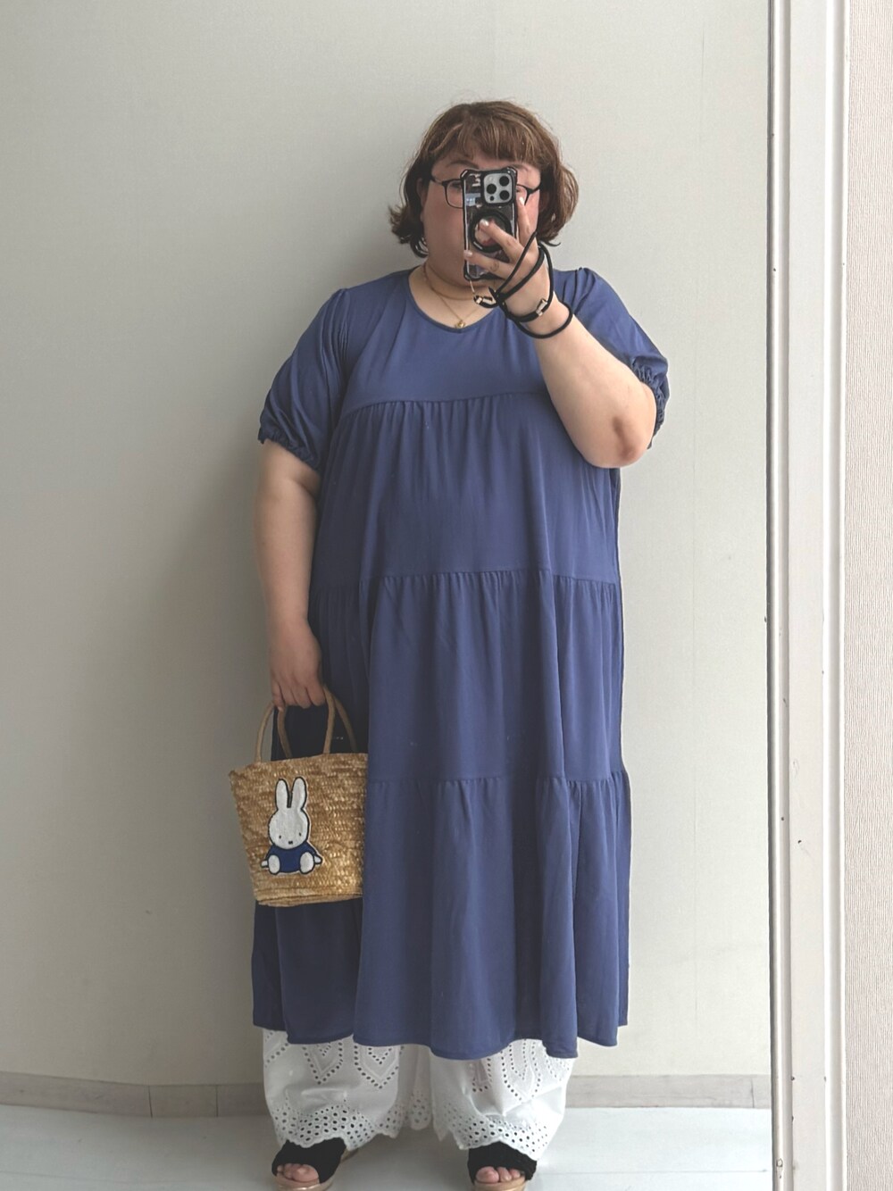 ブルー系のトートバッグ、ブルー系のワンピース、ホワイト系のパンツを着用したレディースの夏コーディネートの1枚目の写真