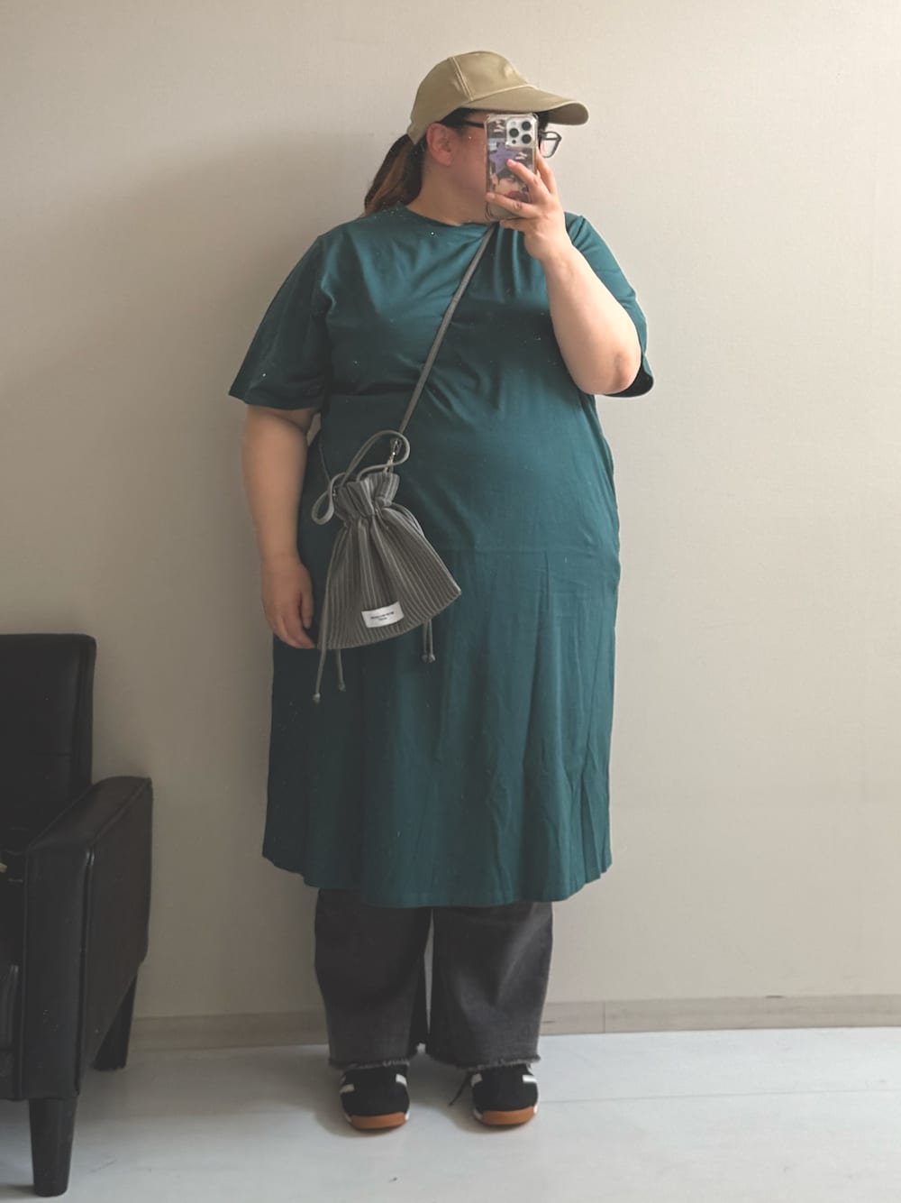 グリーン系のショルダーバッグ、ブラック系のパンツ、グリーン系のワンピースを着用したレディースの春コーディネートの1枚目の写真