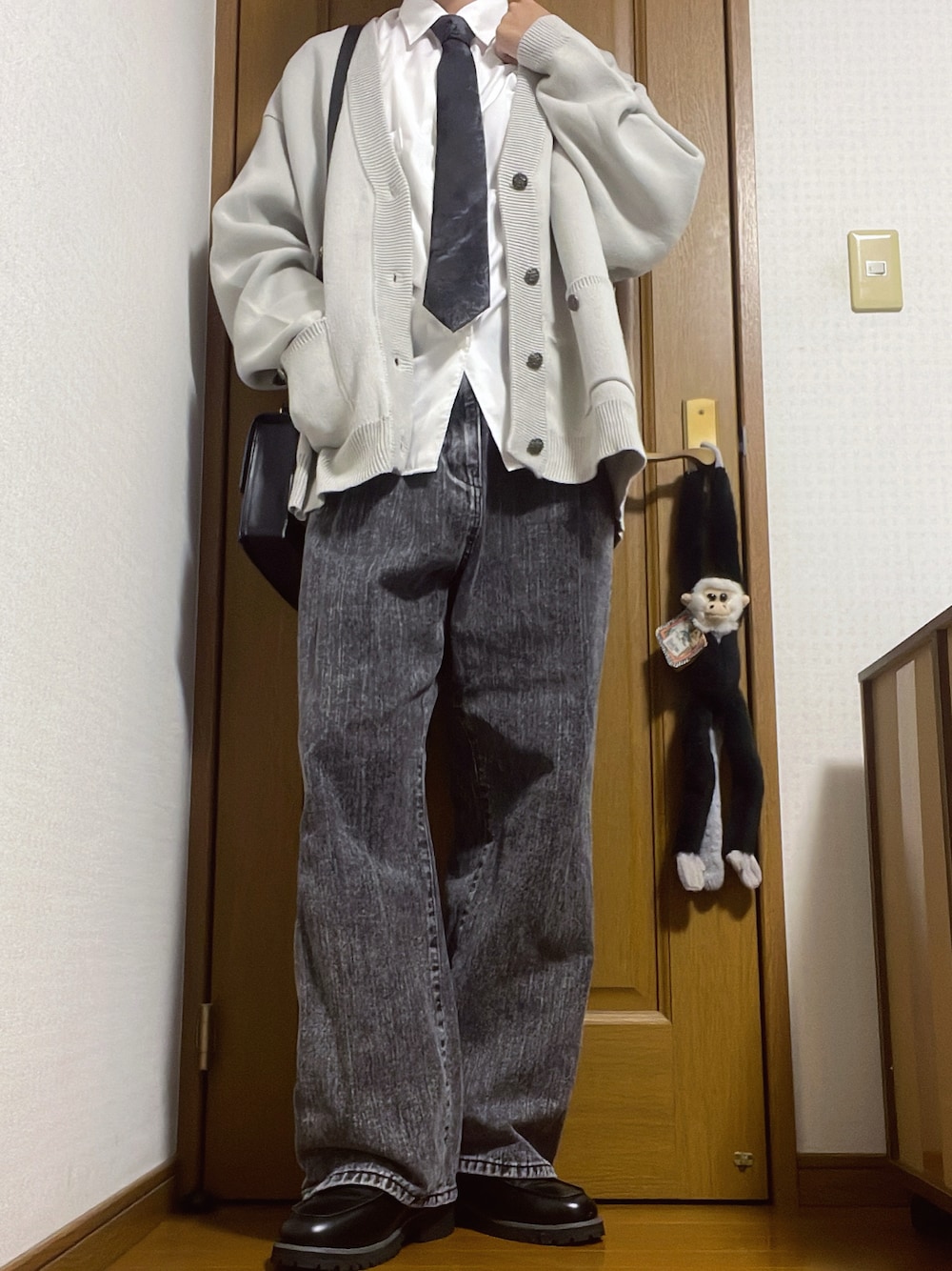 グレー系のカーディガン/ボレロ、ブラック系のネクタイ、ブラック系のデニムパンツを着用したメンズの秋コーディネートの1枚目の写真