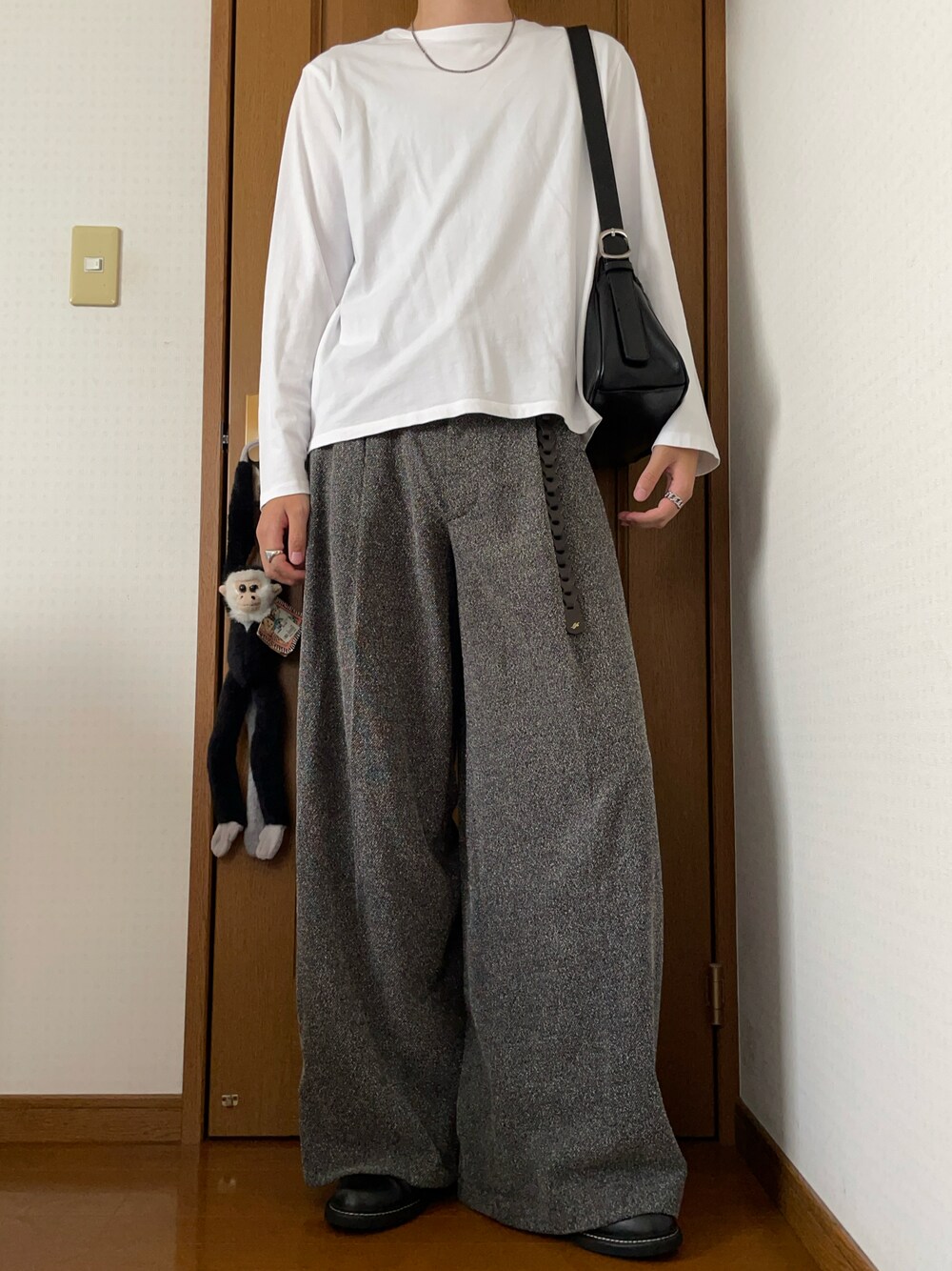 ホワイト系のTシャツ/カットソー、グレー系のスラックス、ブラック系のショルダーバッグを着用したメンズの春コーディネートの1枚目の写真