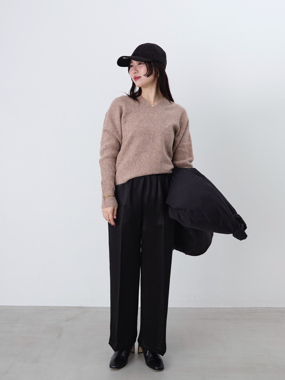 ブラック系のその他パンツ、ブラック系のダウンジャケット/コート、ブラウン系のニット/セーターを着用したレディースの冬コーディネートの1枚目の写真