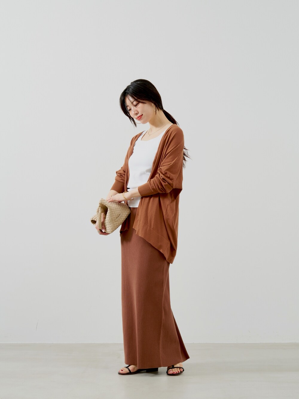 ブラウン系のカーディガン/ボレロ、ホワイト系のタンクトップ、ベージュ系のトートバッグを着用したレディースの夏コーディネートの1枚目の写真