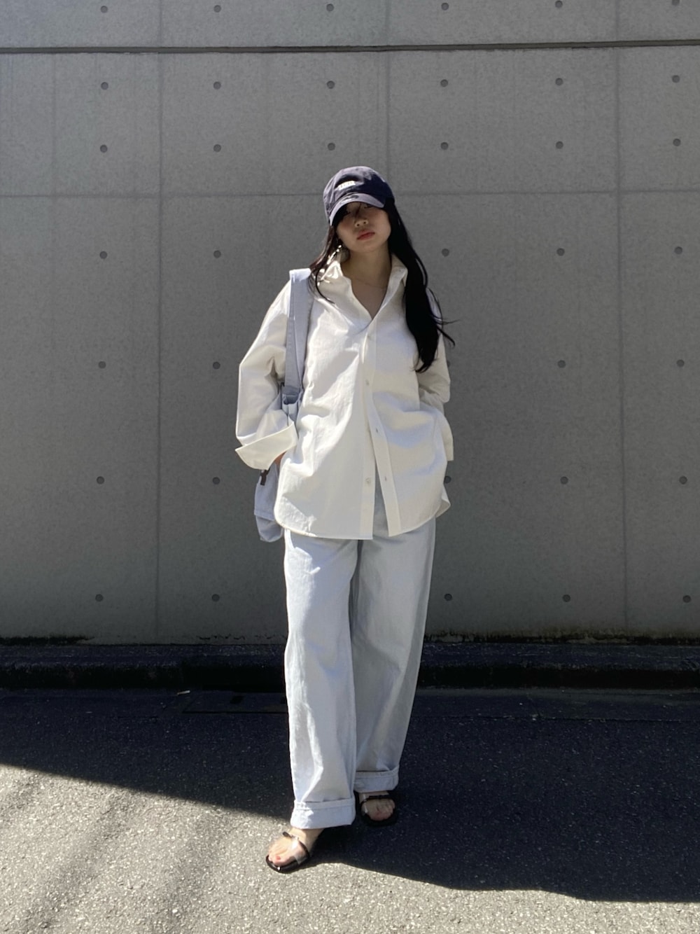 ホワイト系のシャツ/ブラウス、ホワイト系のトートバッグ、ブルー系のデニムパンツを着用したレディースの春コーディネートの1枚目の写真