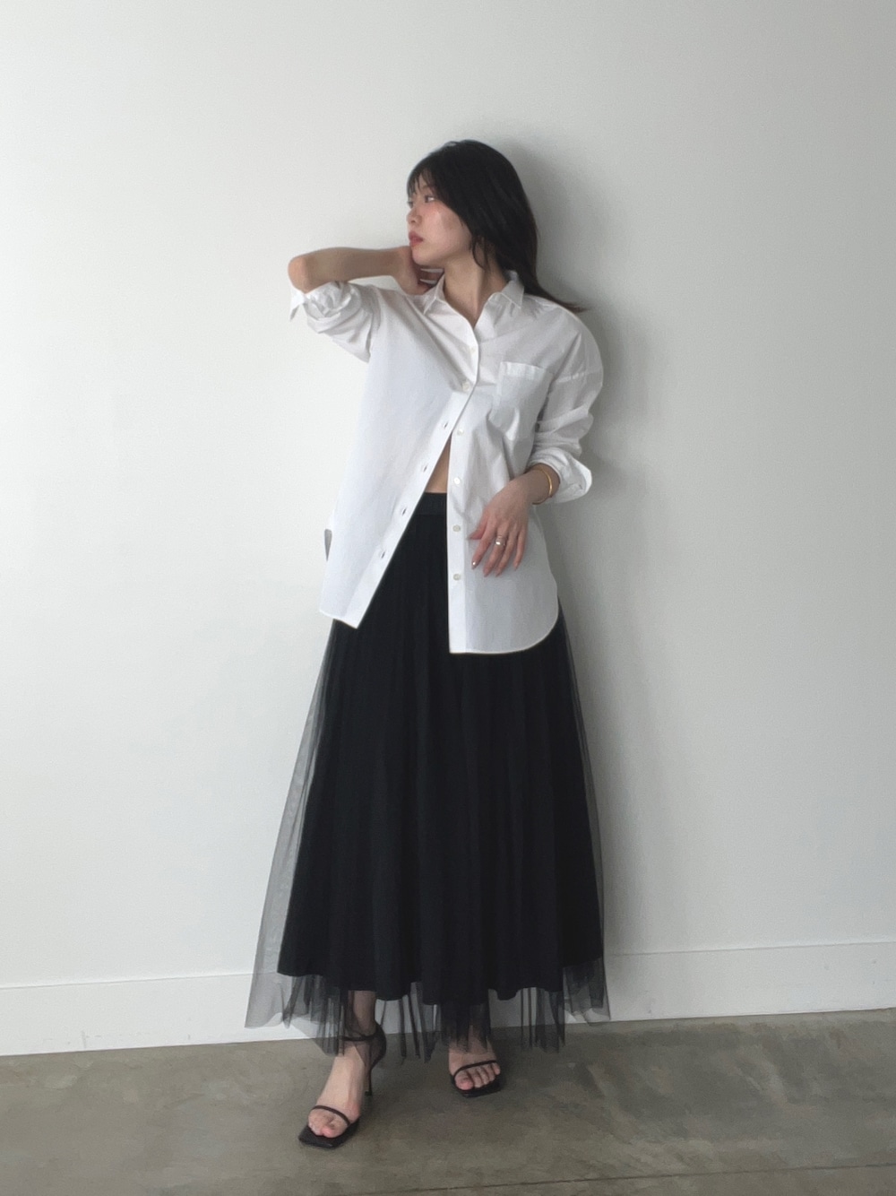 ブラック系のスカート、ホワイト系のシャツ/ブラウスを着用したレディースの春コーディネートの1枚目の写真