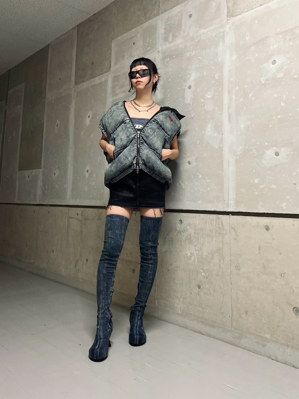ブラック系のデニムスカート、ブルー系のブルゾン、ブルー系のチューブトップを着用したレディースの秋コーディネートの1枚目の写真