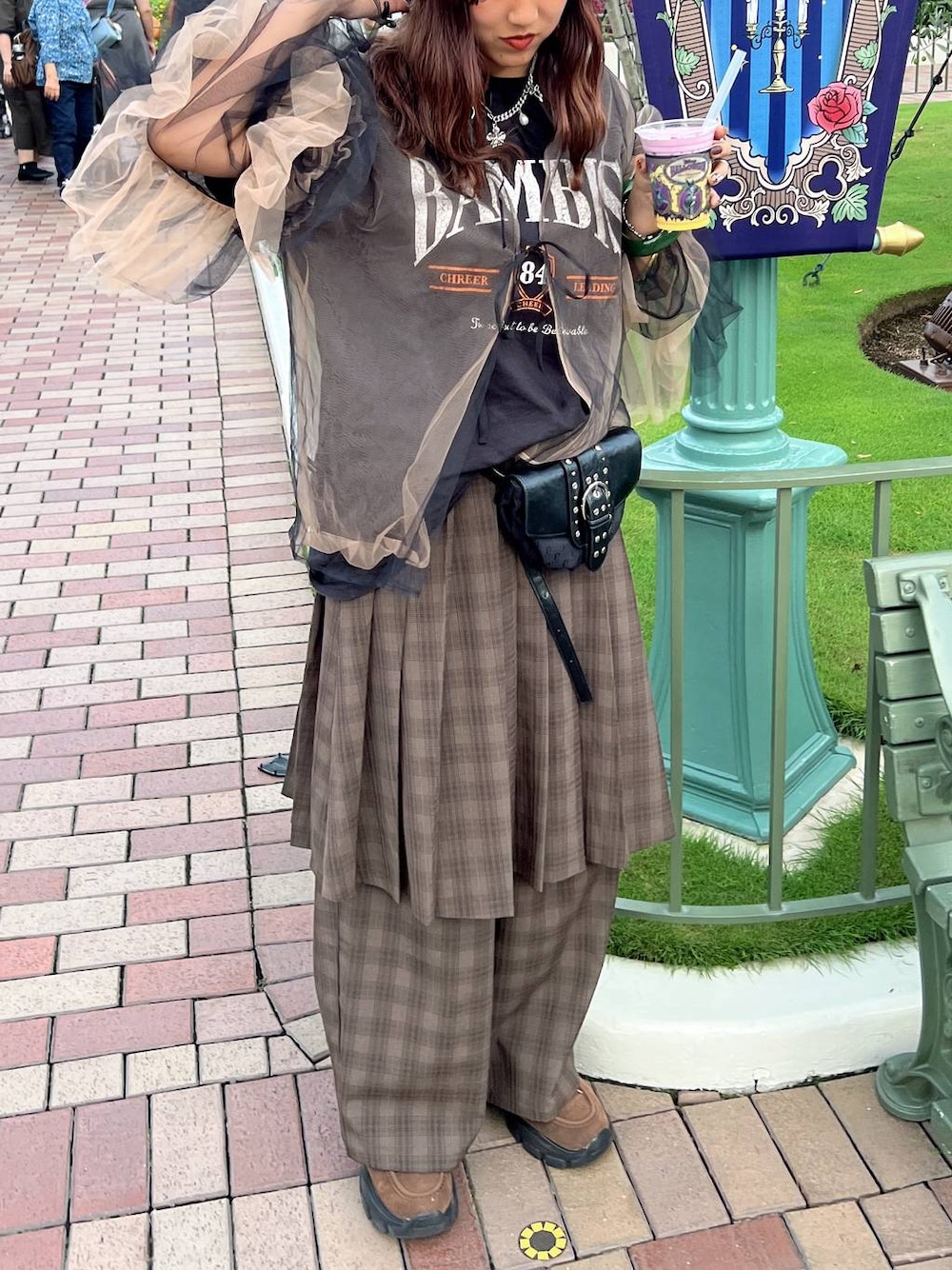 ブラウン系のモカシン/デッキシューズ、ブラック系のショルダーバッグ、グリーン系のスラックスを着用したレディースの秋コーディネートの1枚目の写真