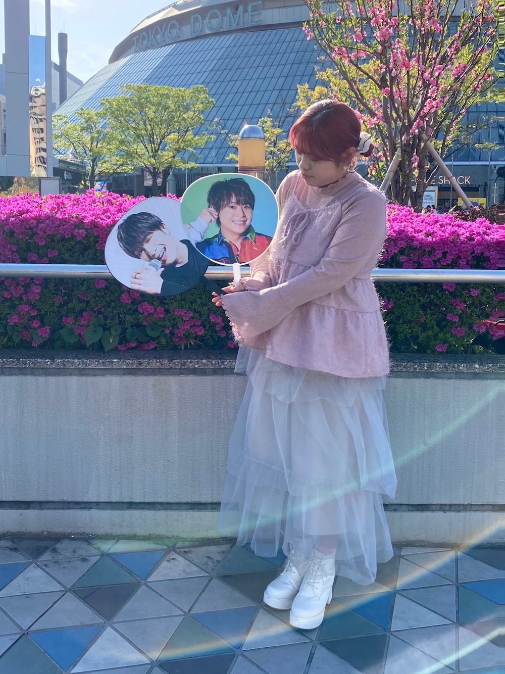 グレー系のスカート、ホワイト系のシューズ、ピンク系のトップスを着用したレディースの春コーディネートの1枚目の写真