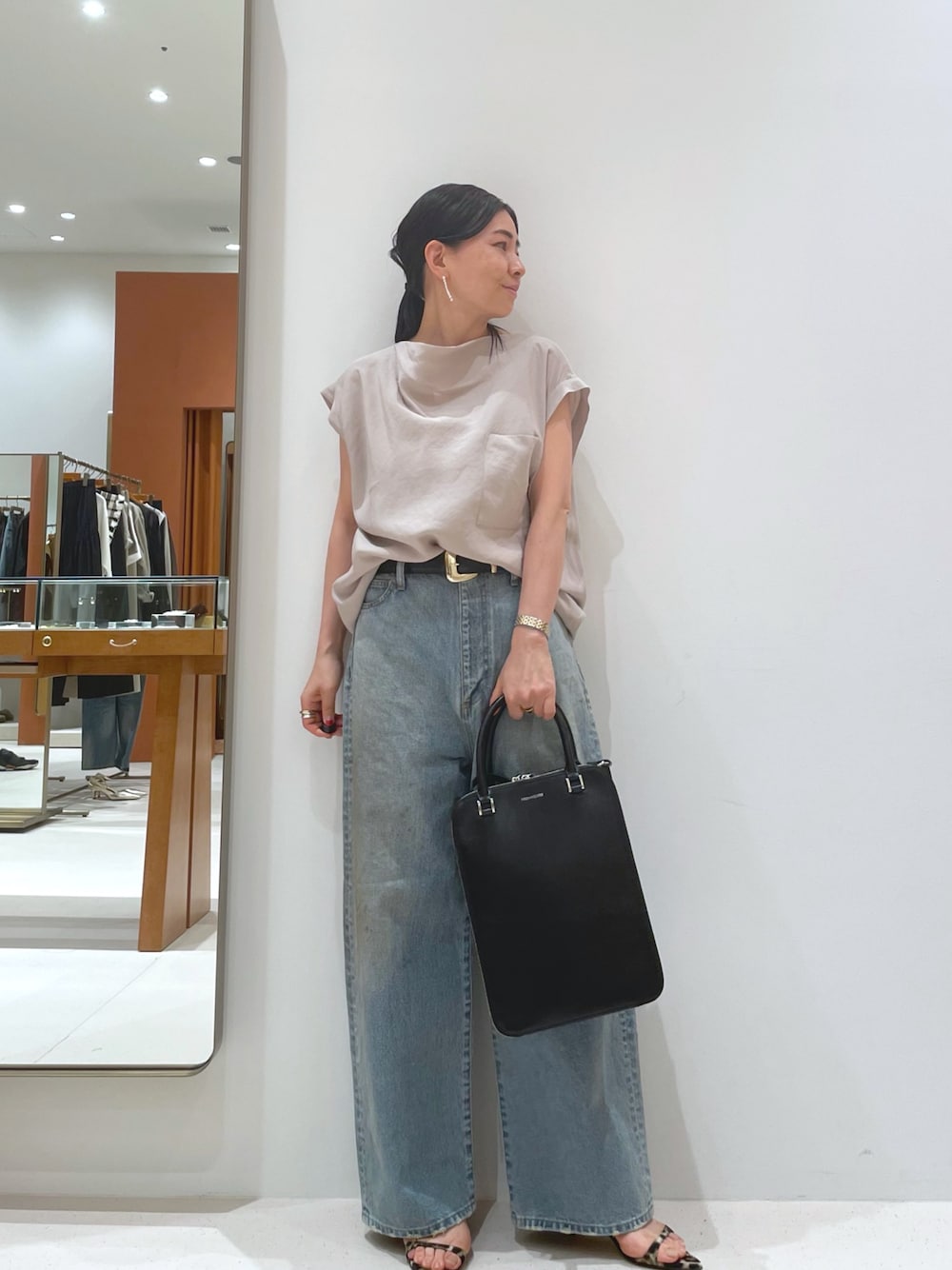 イエロー系のサンダル、ベージュ系のシャツ/ブラウス、ブルー系のデニムパンツを着用したレディースの夏コーディネートの1枚目の写真