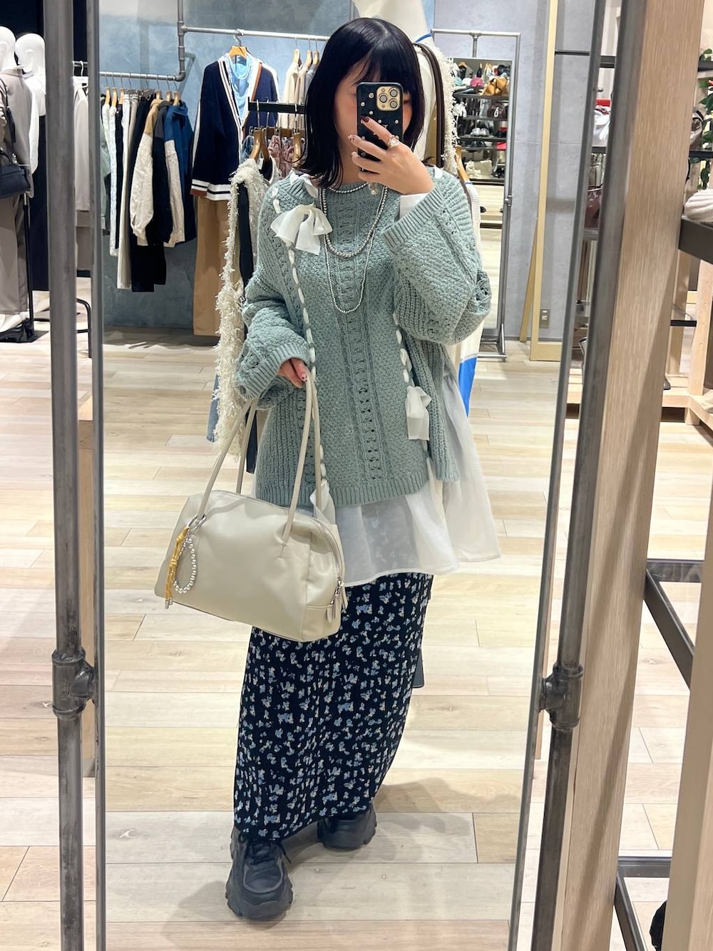 ホワイト系のTシャツ/カットソー、ホワイト系のボストンバッグ、ブラック系のスカートを着用したレディースの冬コーディネートの1枚目の写真