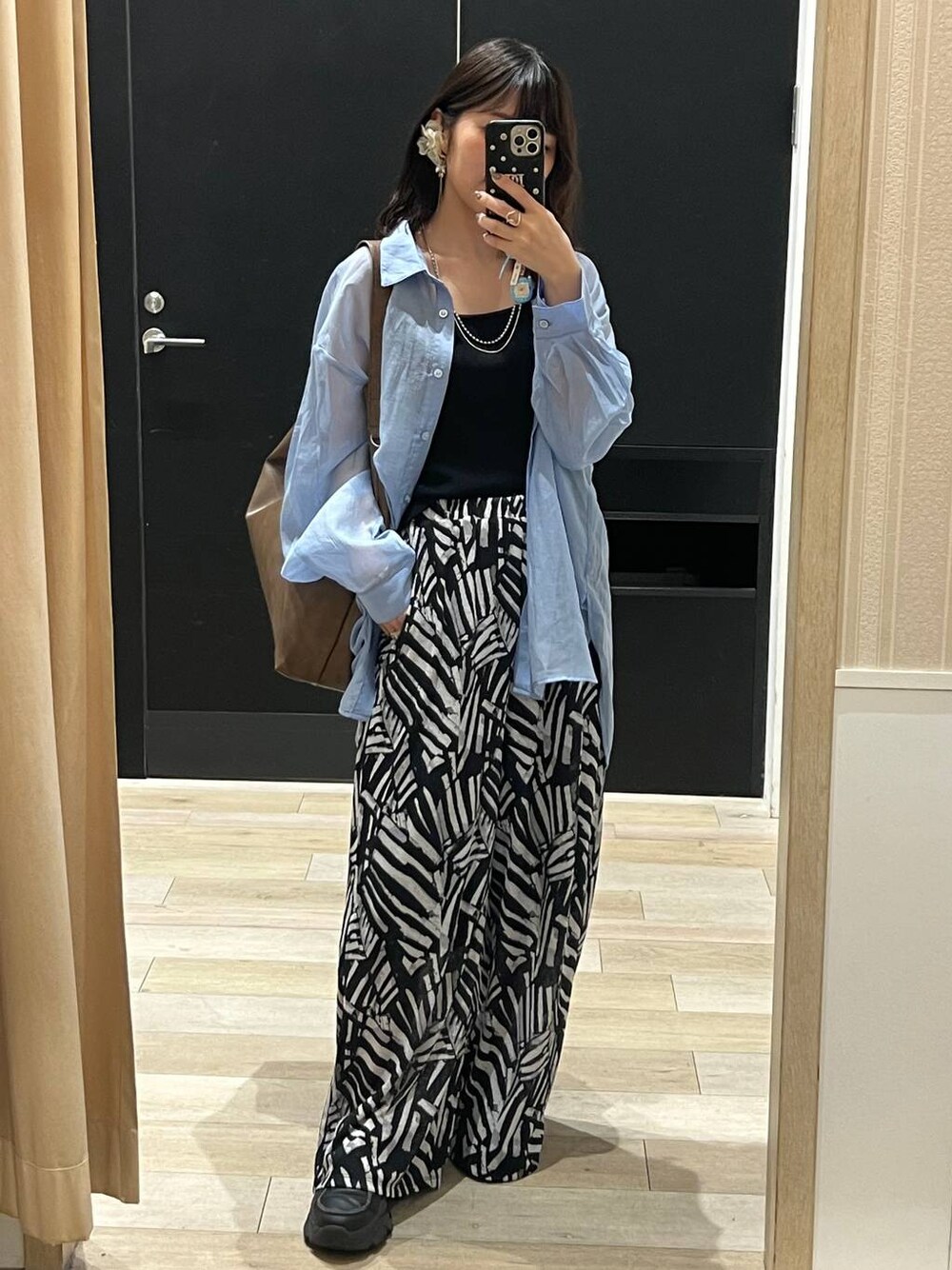 ブルー系のシャツ/ブラウス、ブラック系のその他パンツ、ブラウン系のショルダーバッグを着用したレディースの春コーディネートの1枚目の写真