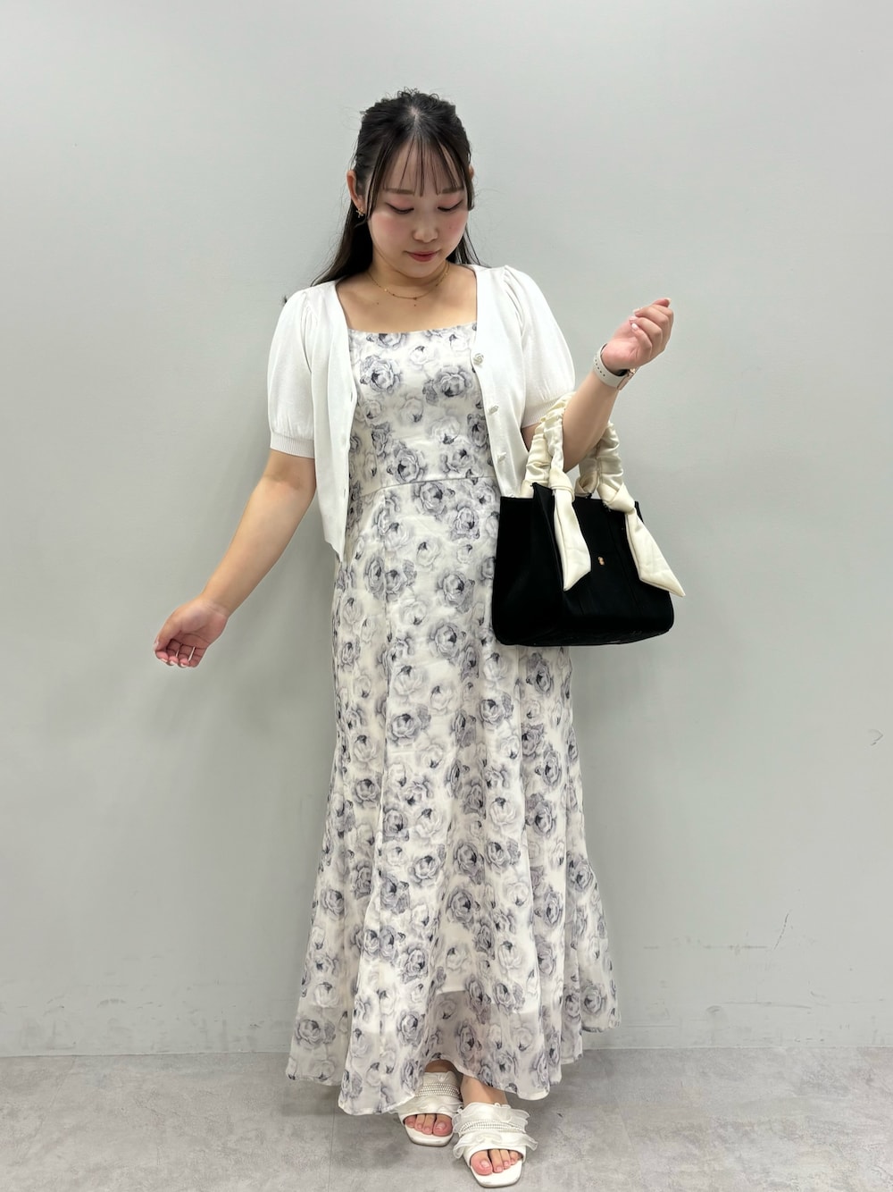 ホワイト系のワンピース、ブラック系のトートバッグ、ホワイト系のカーディガン/ボレロを着用したレディースの夏コーディネートの1枚目の写真