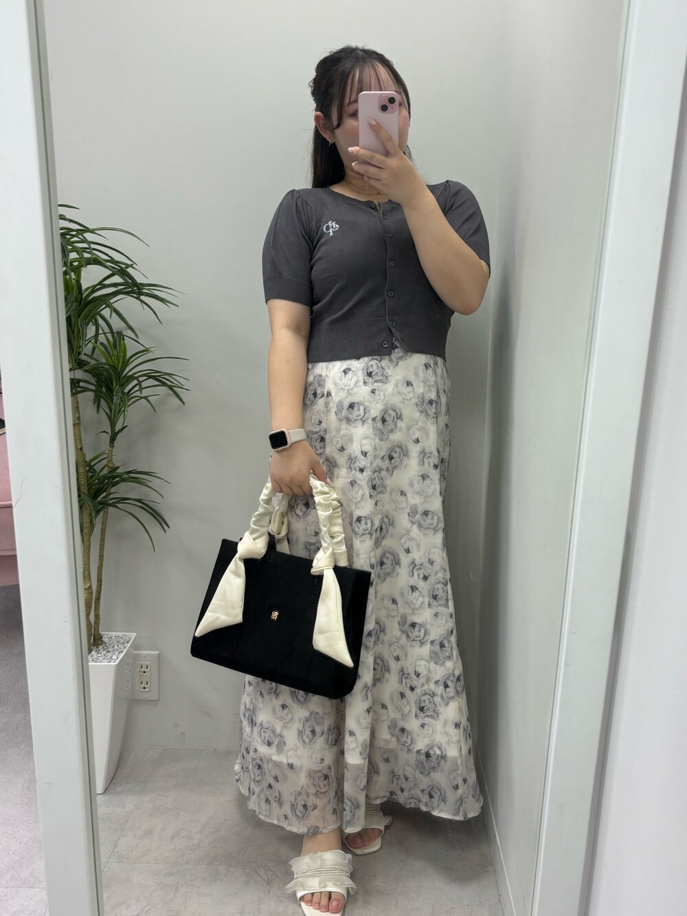 ホワイト系のワンピース、ブラック系のトートバッグ、グレー系のカーディガン/ボレロを着用したレディースの夏コーディネートの1枚目の写真