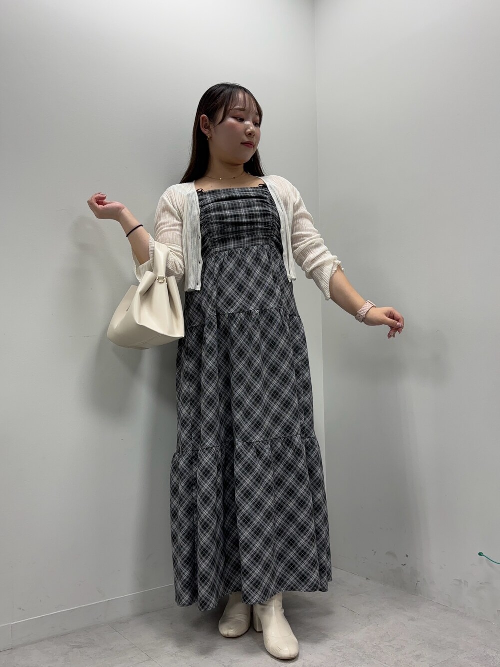 ブラック系のワンピース、ブラウン系のハンドバッグ、ホワイト系のカーディガン/ボレロを着用したレディースの夏コーディネートの1枚目の写真