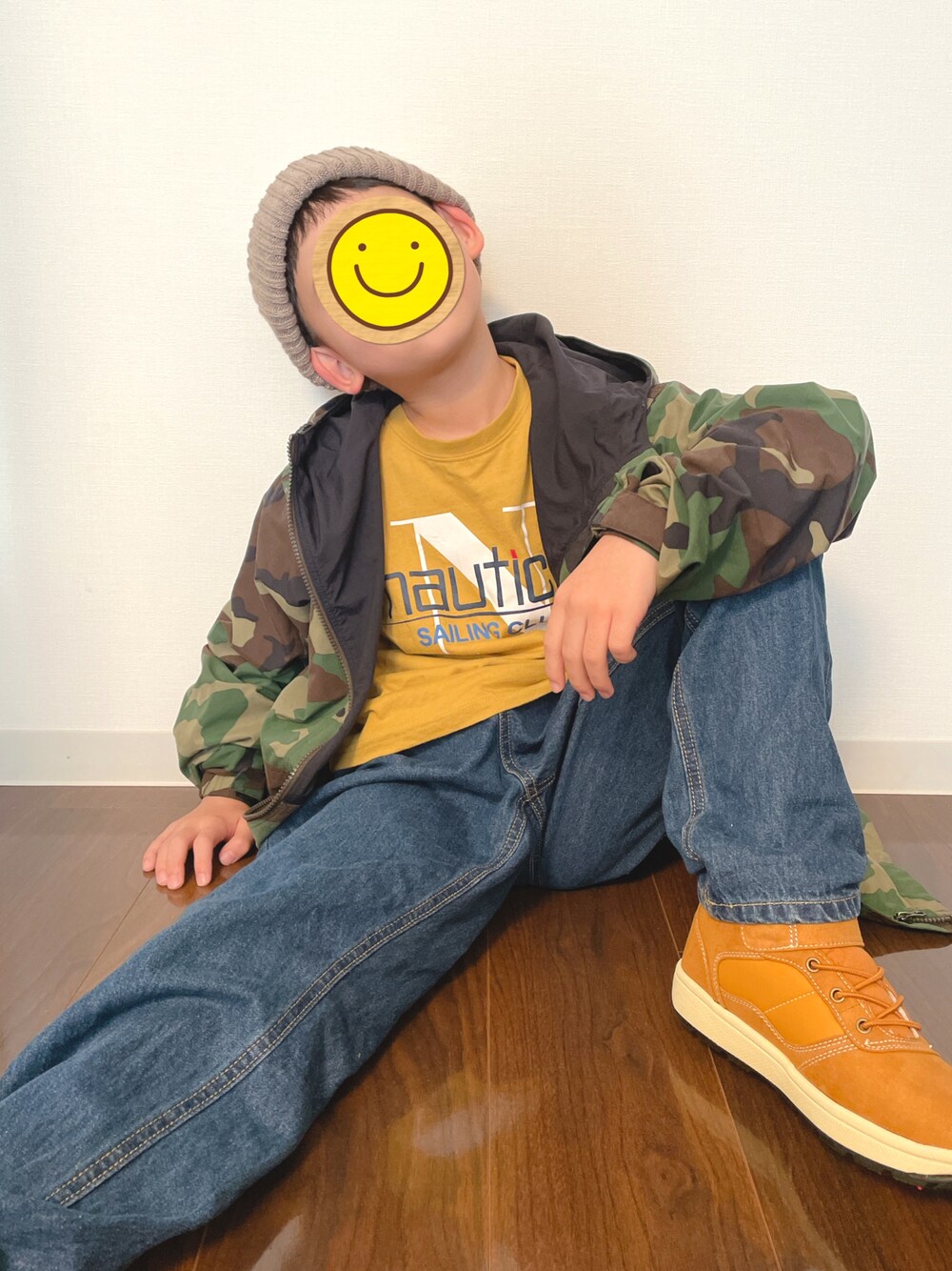 グリーン系のナイロンジャケット、イエロー系のTシャツ/カットソー、ブルー系のその他パンツを着用したキッズの秋コーディネートの1枚目の写真