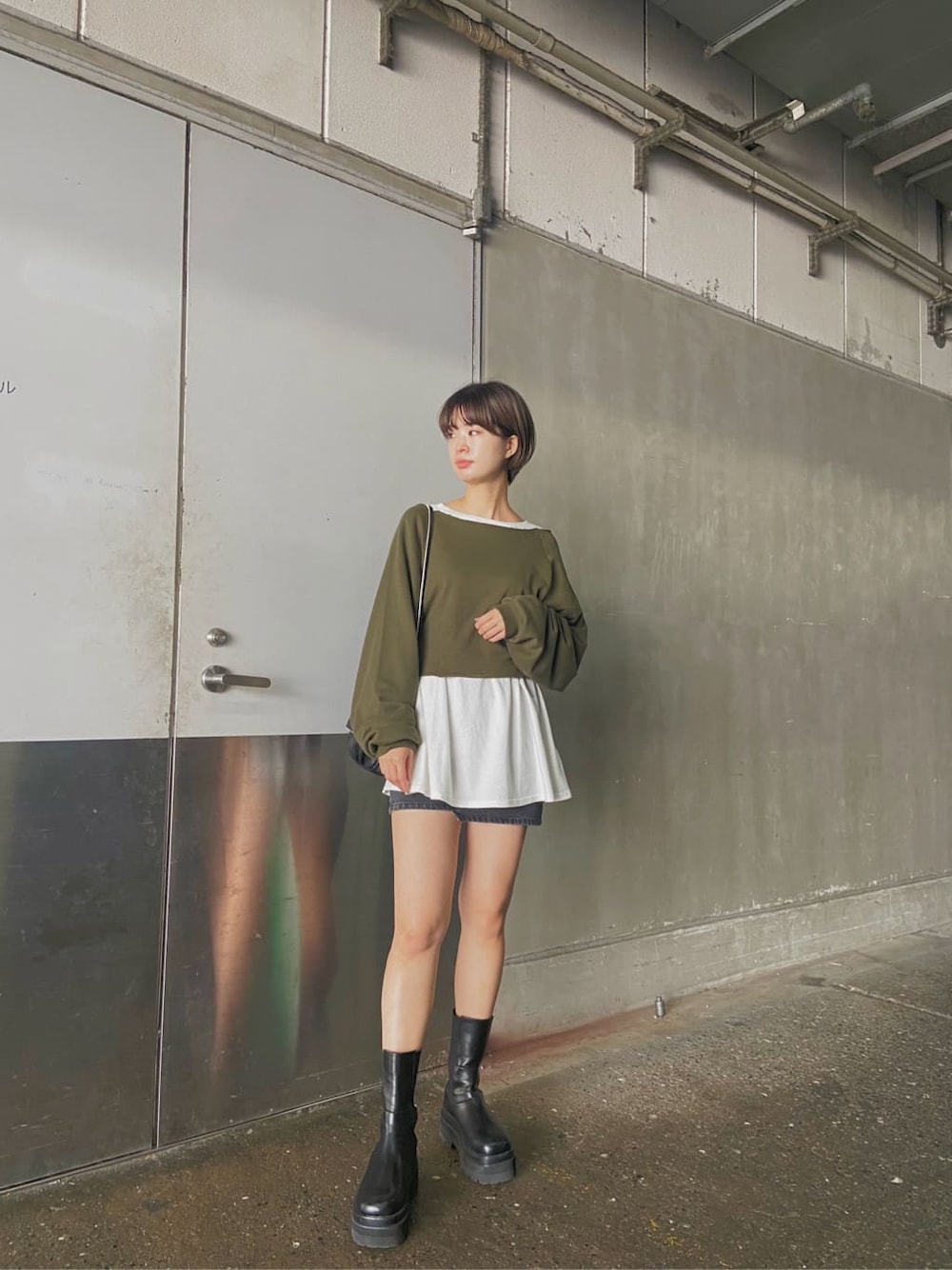 グレー系のスカート、ブラック系のショルダーバッグ、ホワイト系のTシャツ/カットソーを着用したレディースの秋コーディネートの1枚目の写真