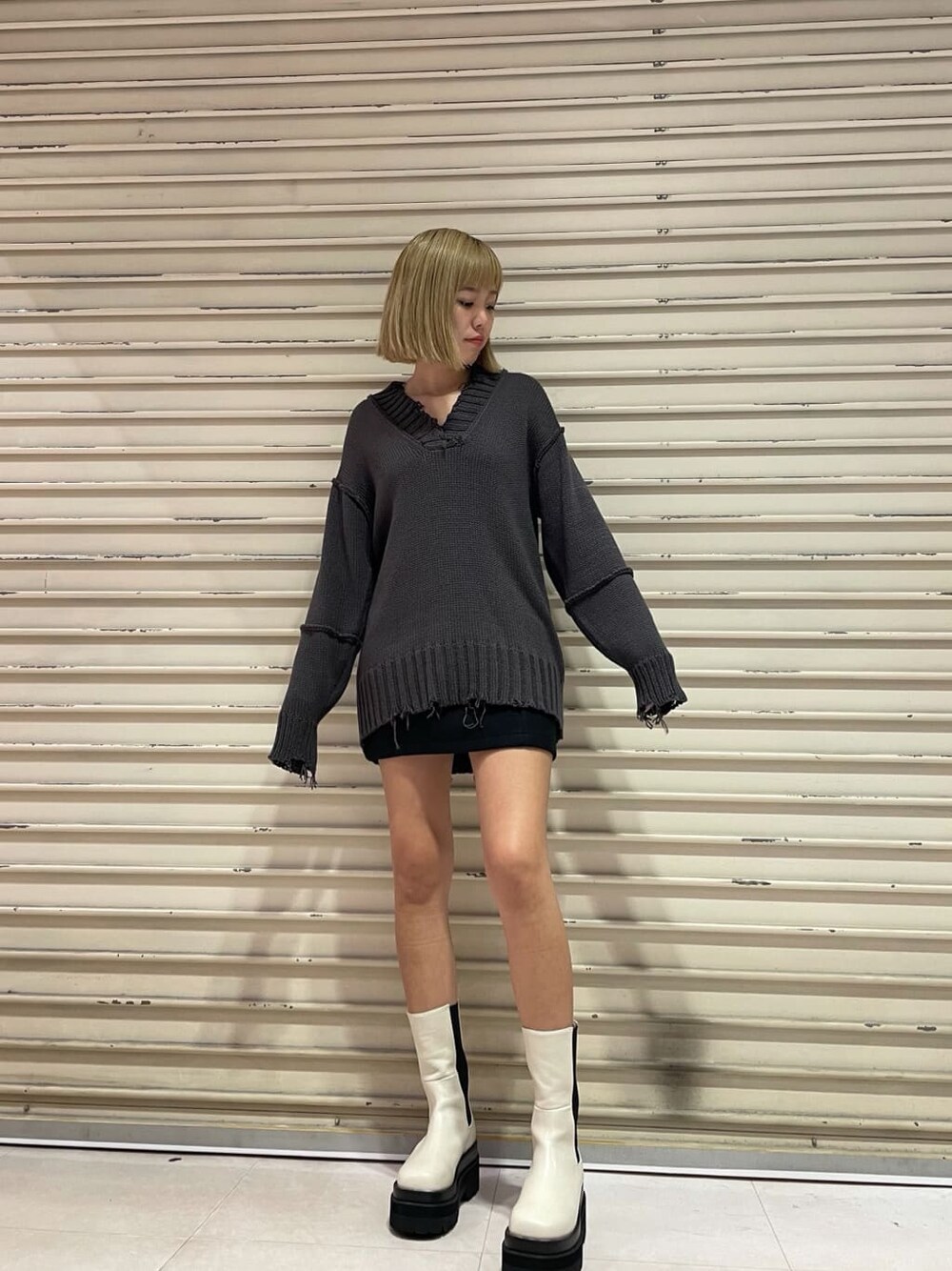 ブラック系のスカート、グレー系のニット/セーターを着用したレディースの秋コーディネートの1枚目の写真