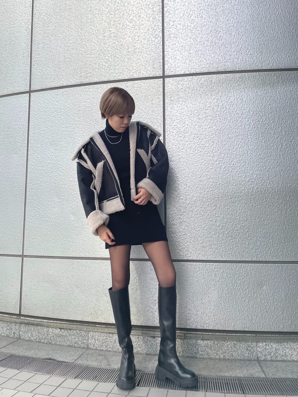 ブラック系のワンピース、その他のムートンコート、ブラック系のブーツを着用したレディースの冬コーディネートの1枚目の写真