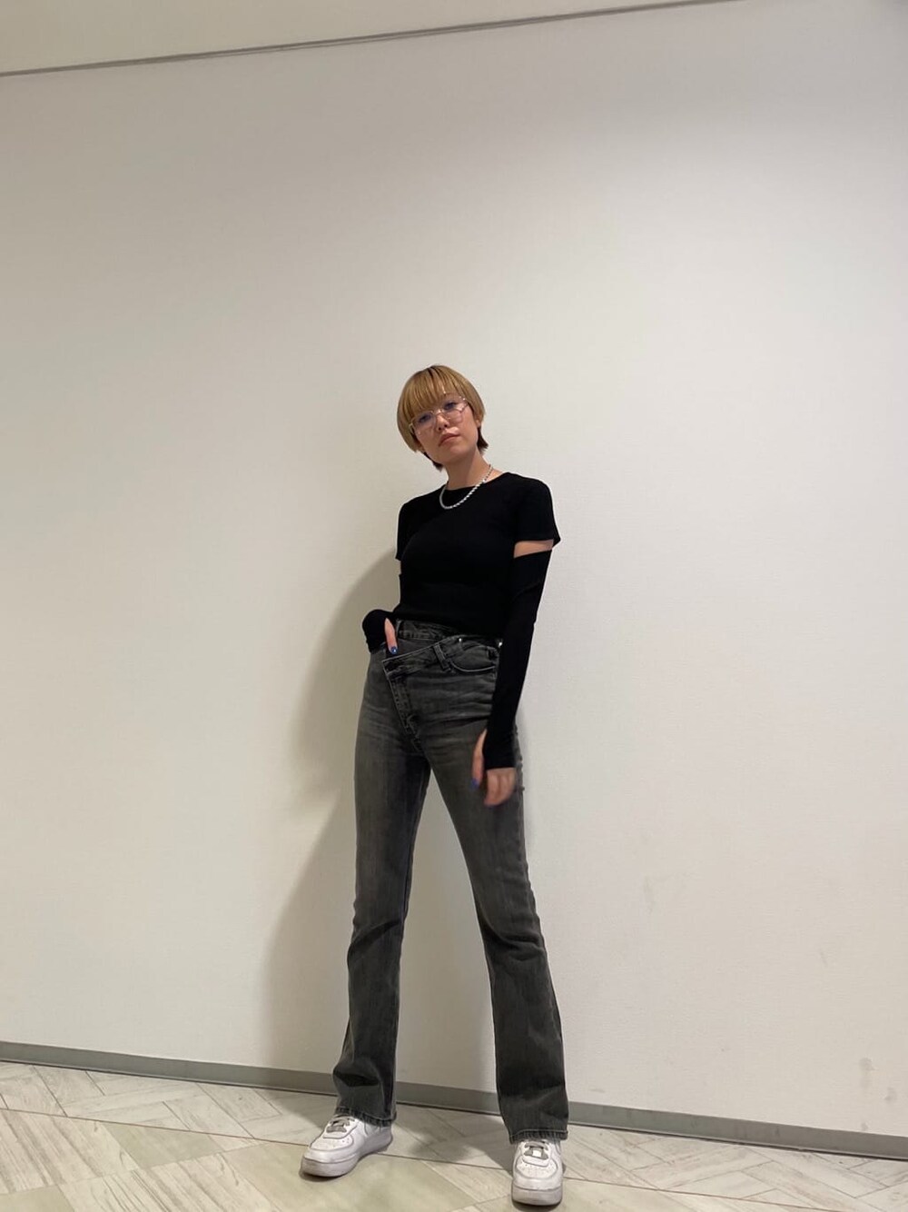 グレー系のデニムパンツ、ブラック系のTシャツ/カットソー、ブラック系のメガネを着用したレディースの春コーディネートの1枚目の写真