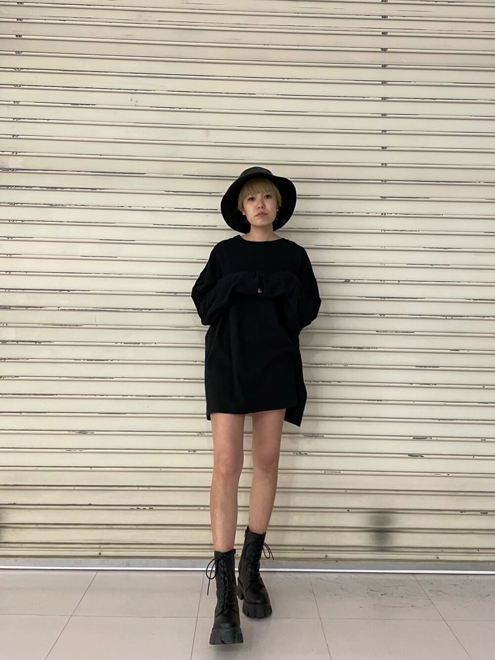 ブラック系のブーツ、ブラック系のTシャツ/カットソー、ブラック系のハットを着用したレディースの冬コーディネートの1枚目の写真