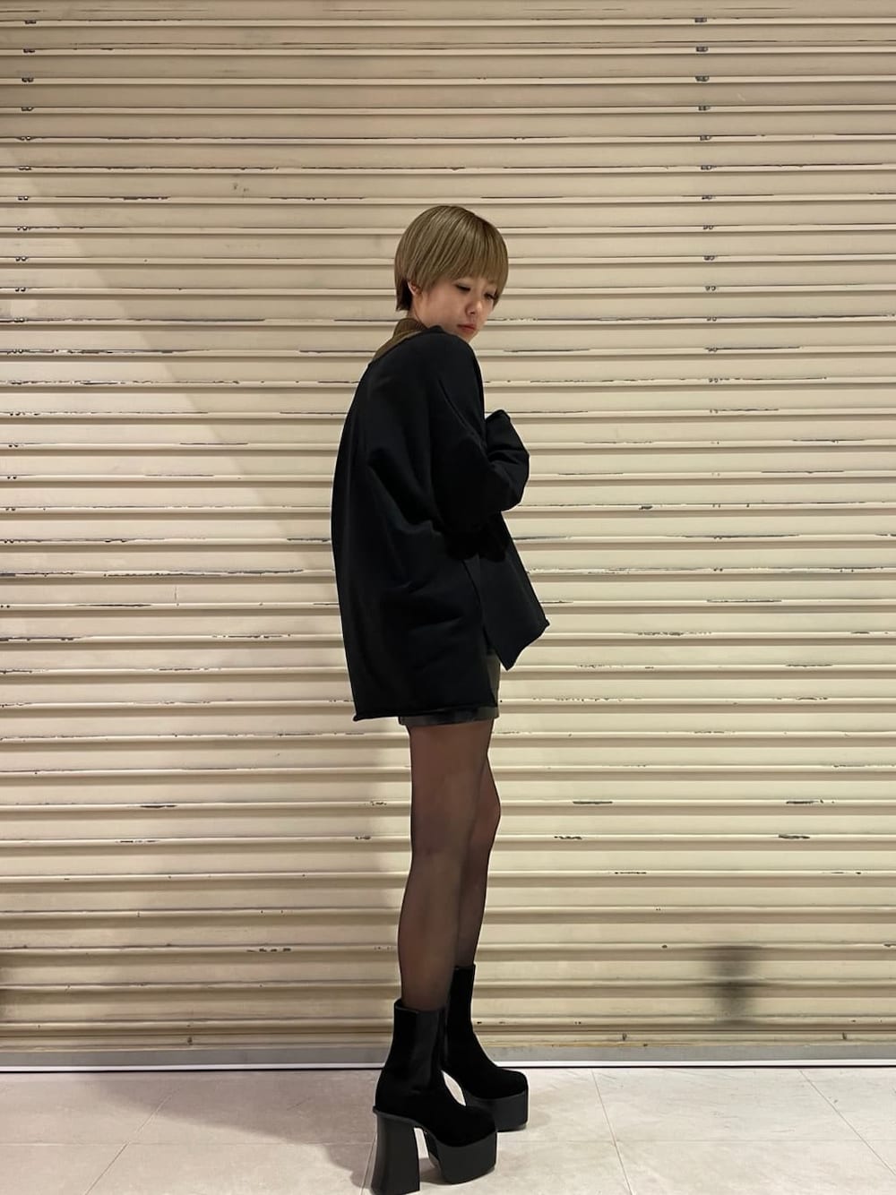 ブラック系のブーツ、ブラック系のスカート、ブラウン系のTシャツ/カットソーを着用したレディースの冬コーディネートの1枚目の写真