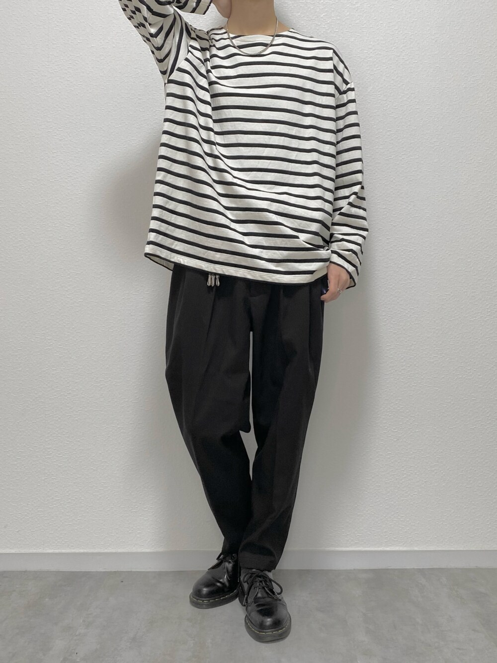 ホワイト系のTシャツ/カットソー、ブラック系のスラックス、ブラック系のブーツを着用したメンズの春コーディネートの1枚目の写真
