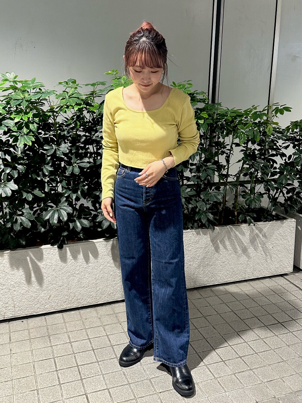 グリーン系のTシャツ/カットソー、ブルー系のデニムパンツを着用したレディースの秋コーディネートの1枚目の写真