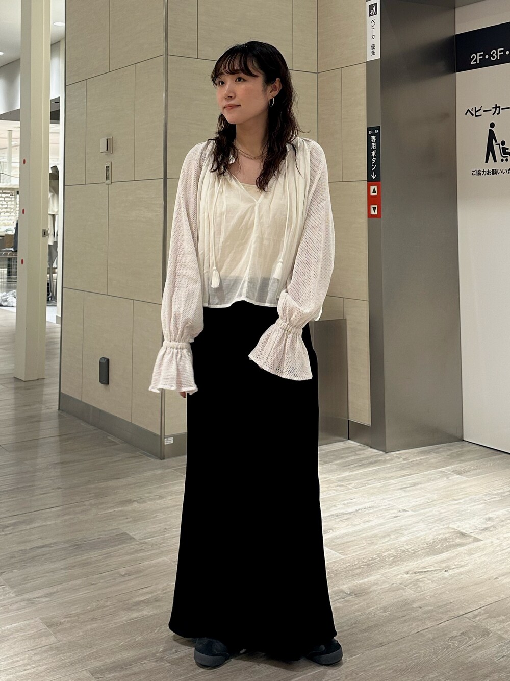 ホワイト系のシャツ/ブラウス、ブラック系のスカートを着用したレディースの秋コーディネートの1枚目の写真