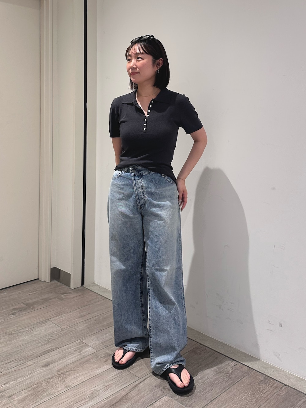 グレー系のニット/セーター、ブルー系のデニムパンツを着用したレディースの夏コーディネートの1枚目の写真