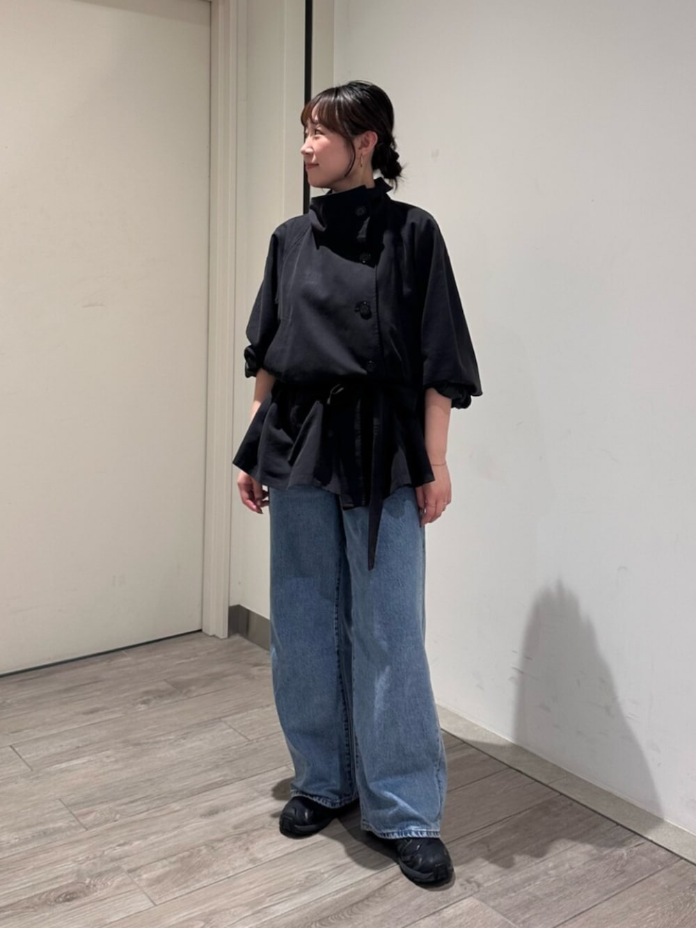 ブルー系のデニムパンツ、グレー系のトレンチコートを着用したレディースの秋コーディネートの1枚目の写真