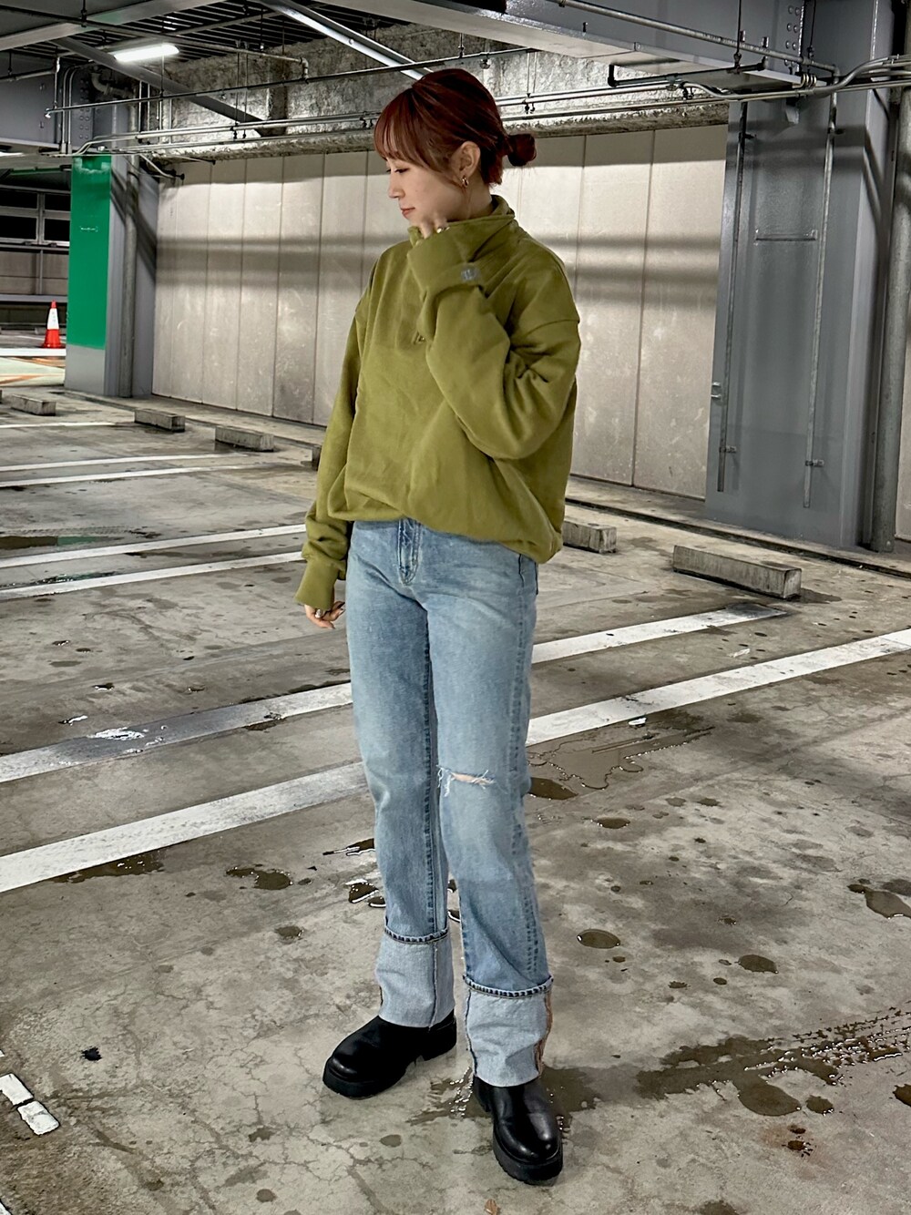 グリーン系のスウェット、ブルー系のデニムパンツを着用したレディースの冬コーディネートの1枚目の写真